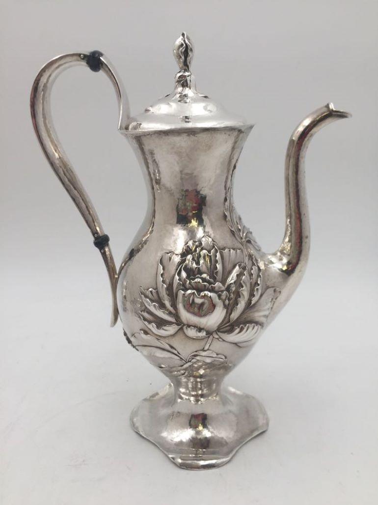 Barbour & Co. sterling silver three-piece demitasse tea set in the Martele Art Nouveau style, with beautiful intricate floral design and exquisitely hand hammered, consisting of:

- a tea pot, measuring 9 1/2'' in height by 7 1/8'' from handle to