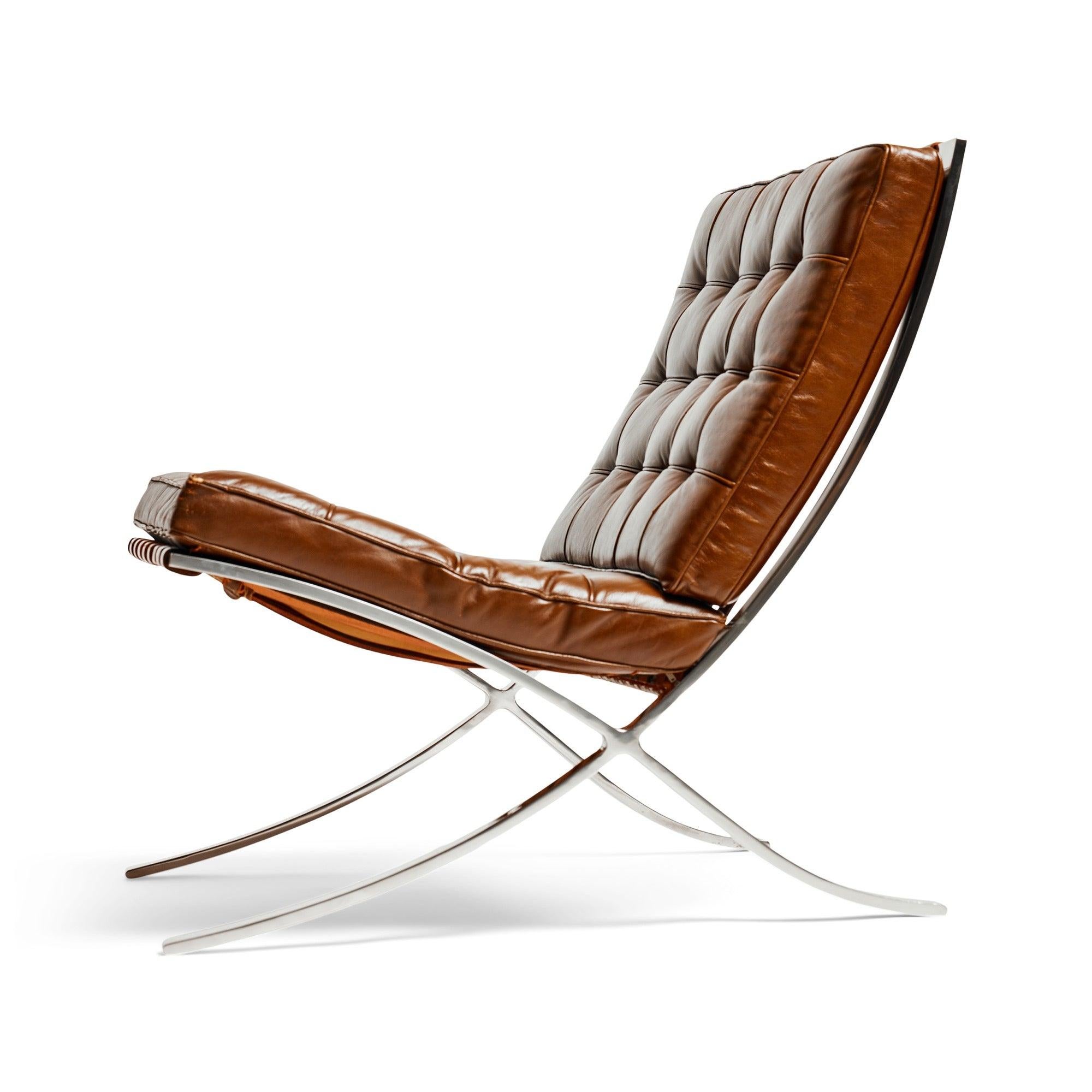 A 'Barcelona' chair, with brown leather upholstery and belting straps on a chromed steel frame.??