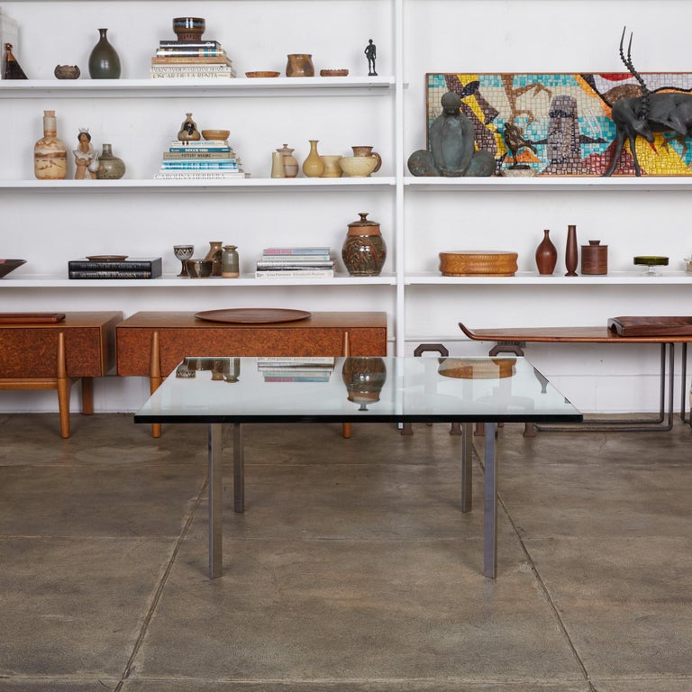 The iconic Barcelona coffee table from Ludwig Mies van der Rohe’s 1929 collection. Brought back into production for midcentury consumers by Knoll, the table has an X-shaped base, a single piece of flat-bar steel with a polished chrome finish. A