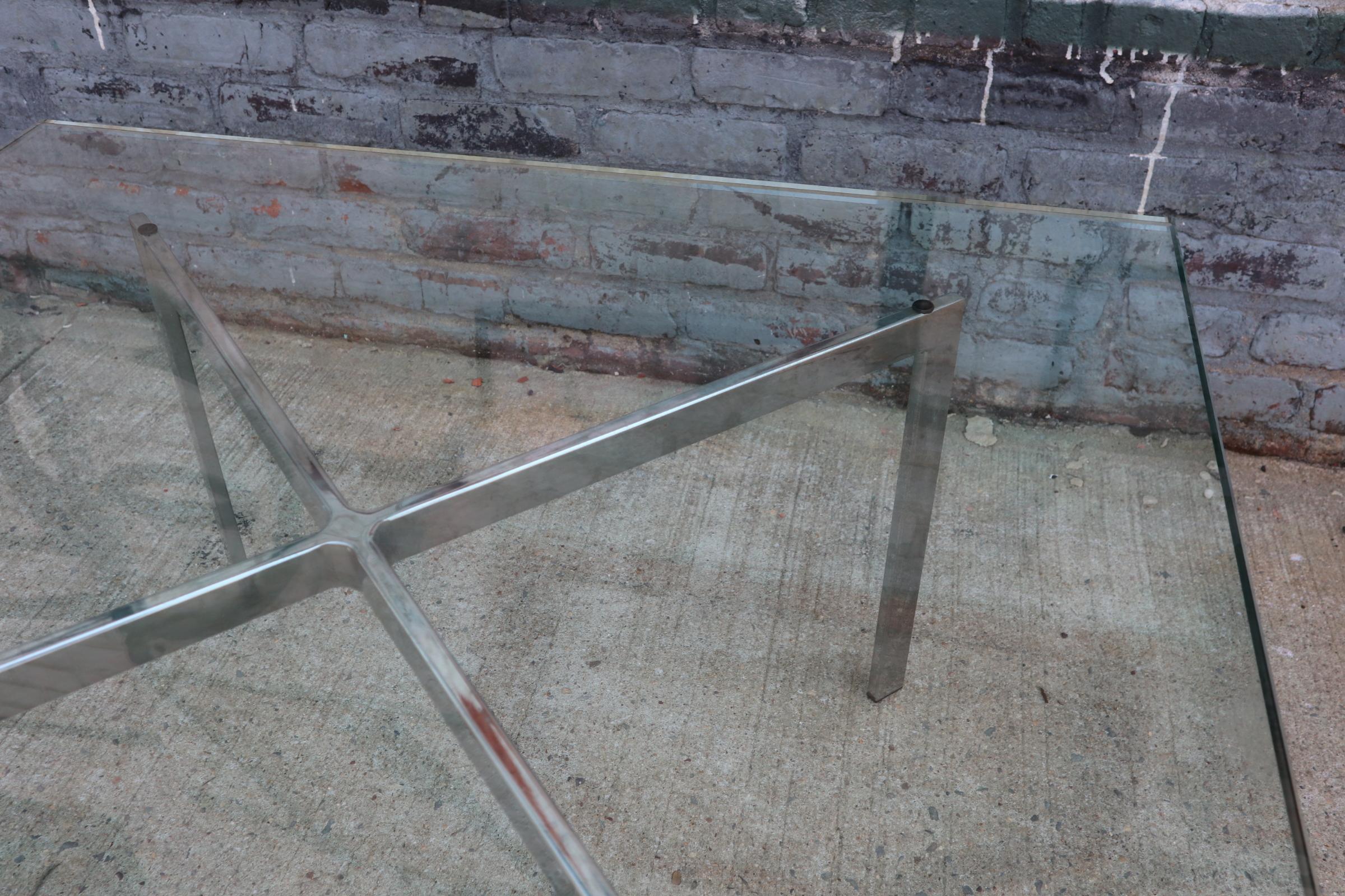 Elegant Barcelona style coffee table. Thick heavy glass slap on polished chrome base. Unsigned. Sturdy and presents very well. No chips to glass corners.