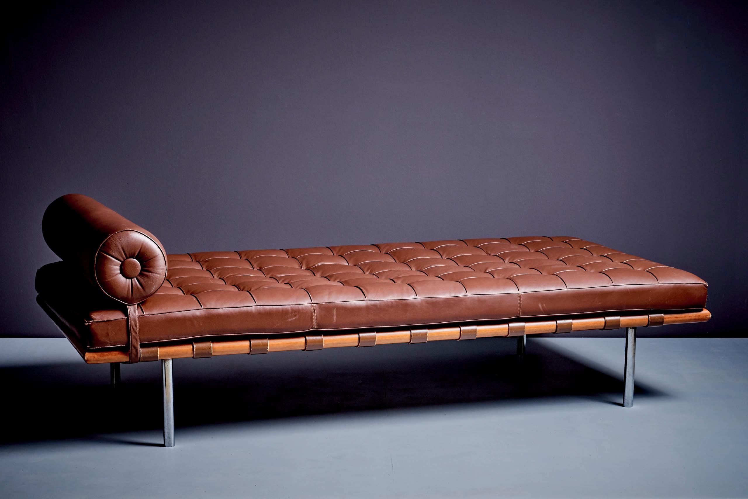 Dieses ikonische Daybed verbindet die Schlichtheit des Bauhauses mit raffinierter Handwerkskunst. Er ist mit braunem Leder gepolstert, hat ein getuftetes Kissen und eine Nackenrolle und ruht auf einem Massivholzrahmen mit schlanken Stahlbeinen. Der