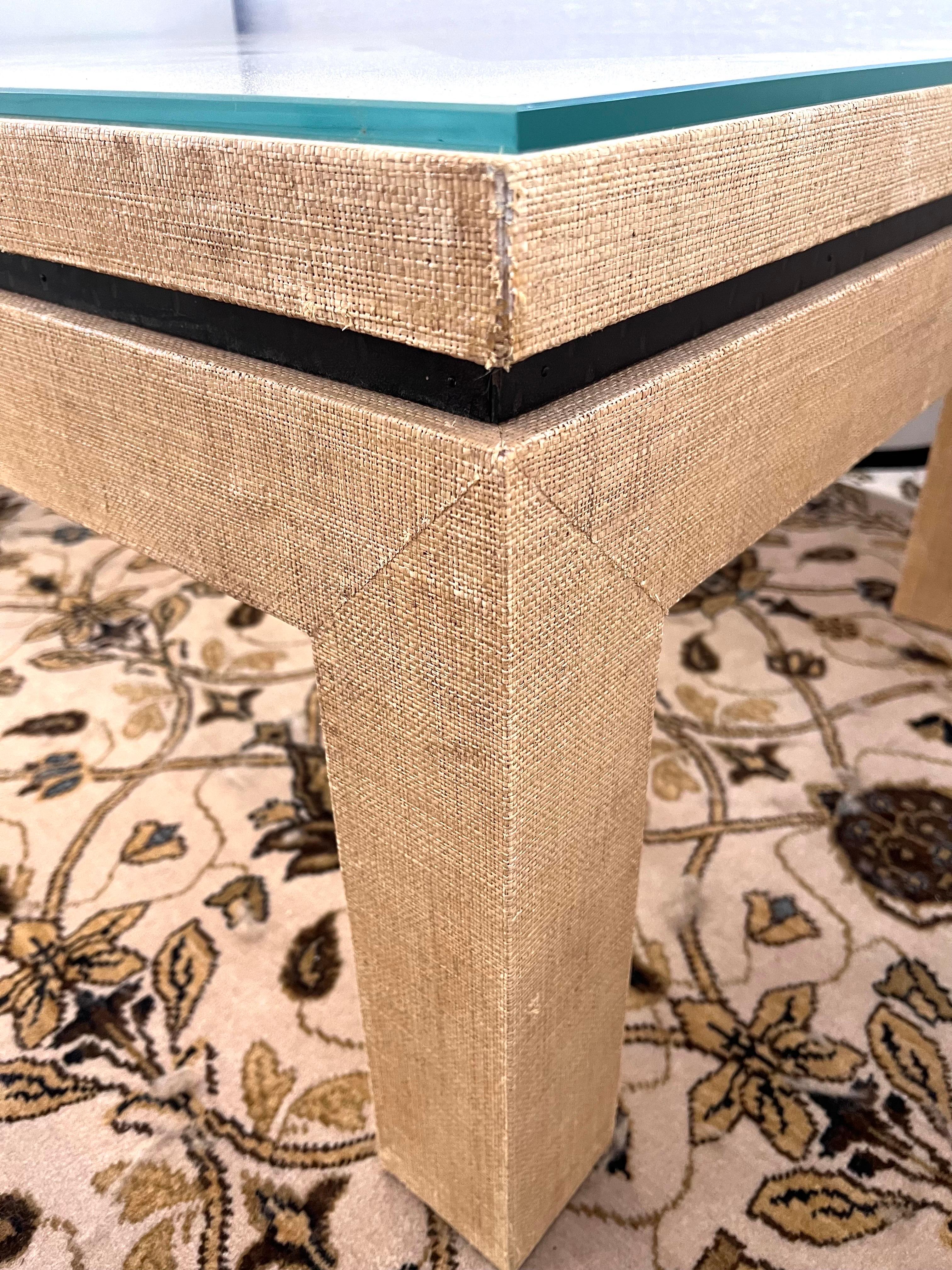 Casual yet elegant natural raffia cocktail table from designer Barclay Butera that features a decorative metal band that separates the base from the top thereby creating a floating appearance.  The corners are mitered giving the design a craftsman