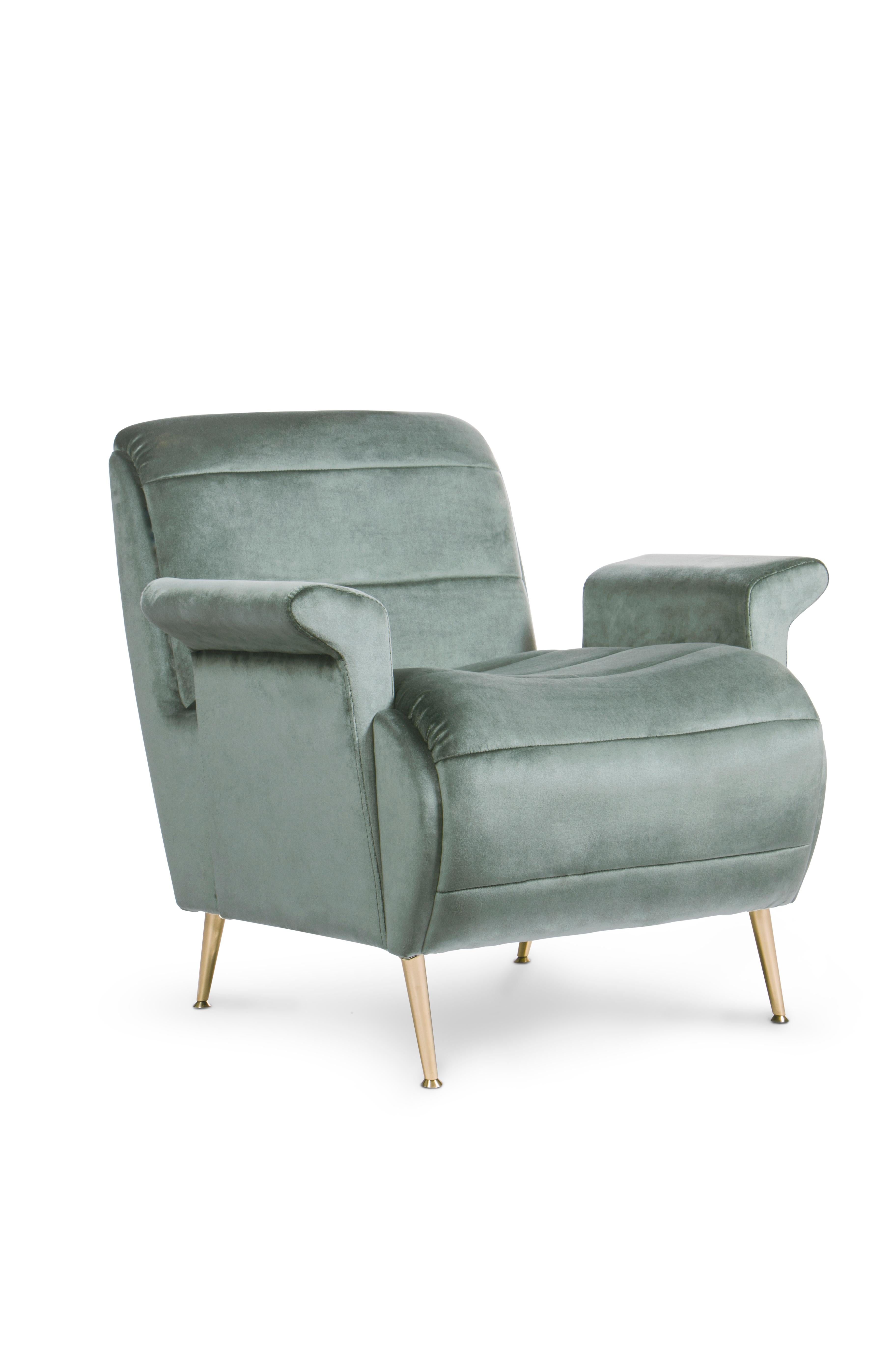 Inspired in the feminine silhouette of Brigitte Bardot, this armchair boasts modern contours, both on the slightly reclined back and on the rolled seat. It is upholstered in velvet and features tiny tapered legs in polished brass. The key shape of