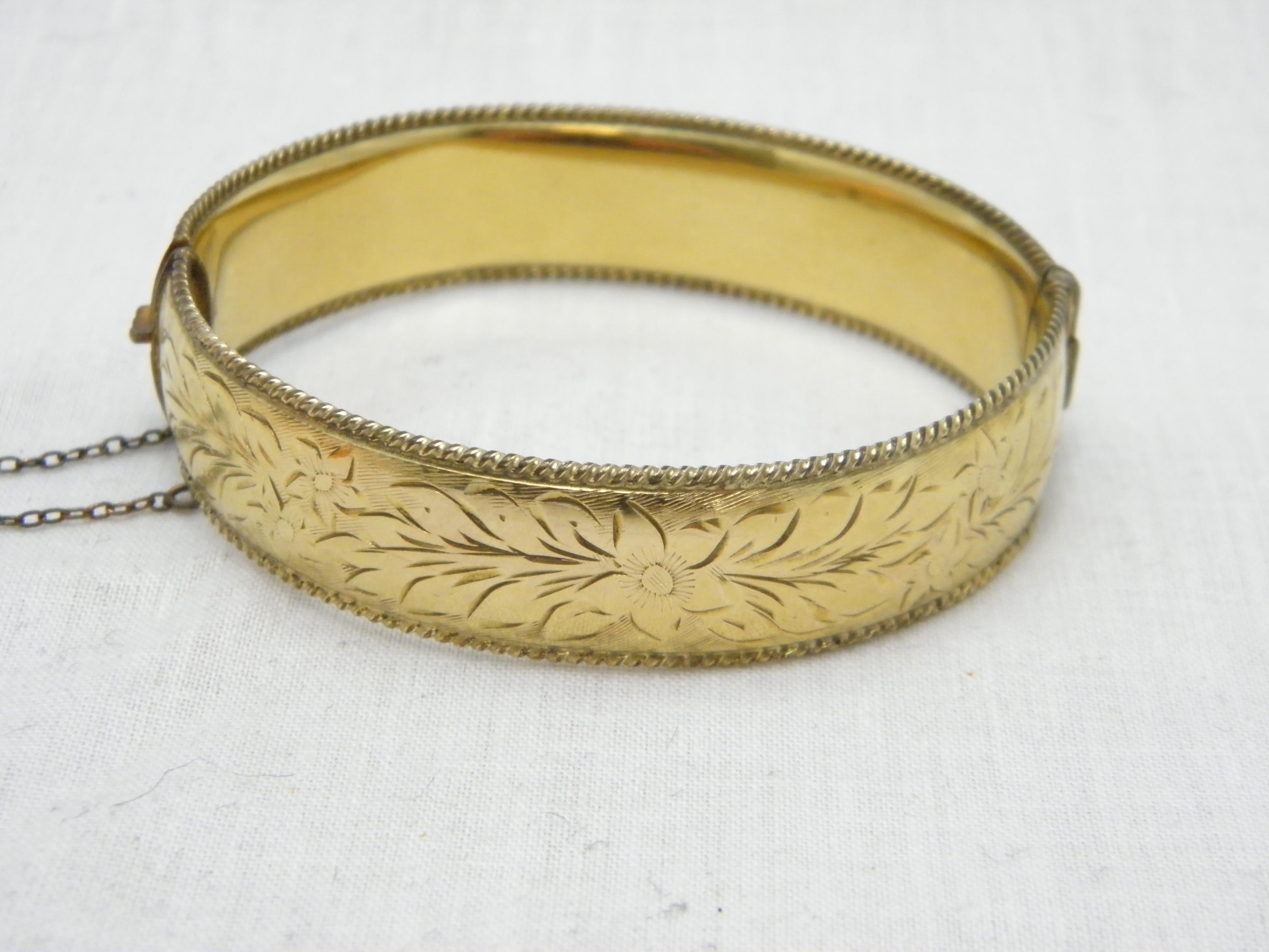 If you have landed on this page then you have an eye for beauty.

On offer is this gorgeous
9CT GOLD METAL CORED FLORAL ENGRAVED HINGED BANGLE BRACELET

DETAILS
Material: Thick 9ct Gold with Metal Core (see details below)
Style: Hinged Cuff with
