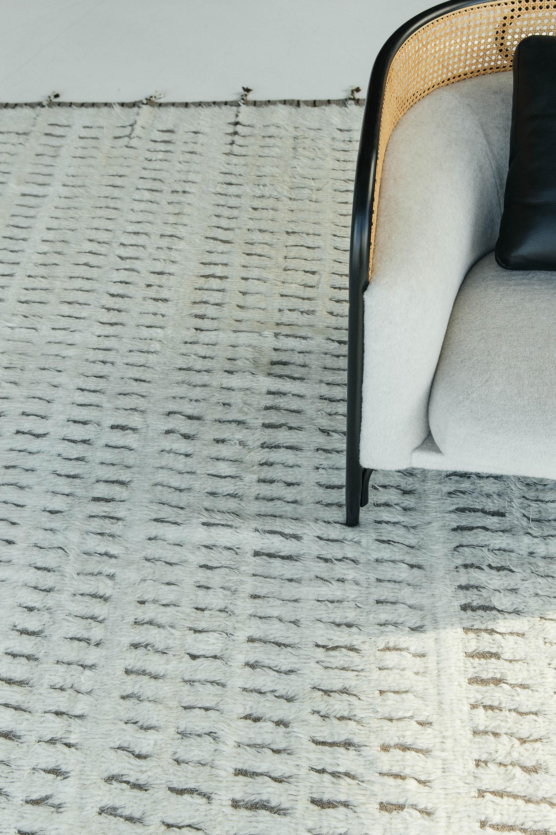 The signature Collection of California. Handwoven luxurious wool rug, made of timeless design elements and neutral earth tones with the perfect shade of ivory. Natural flat weave runs around the border with tasseled ends making this piece from
