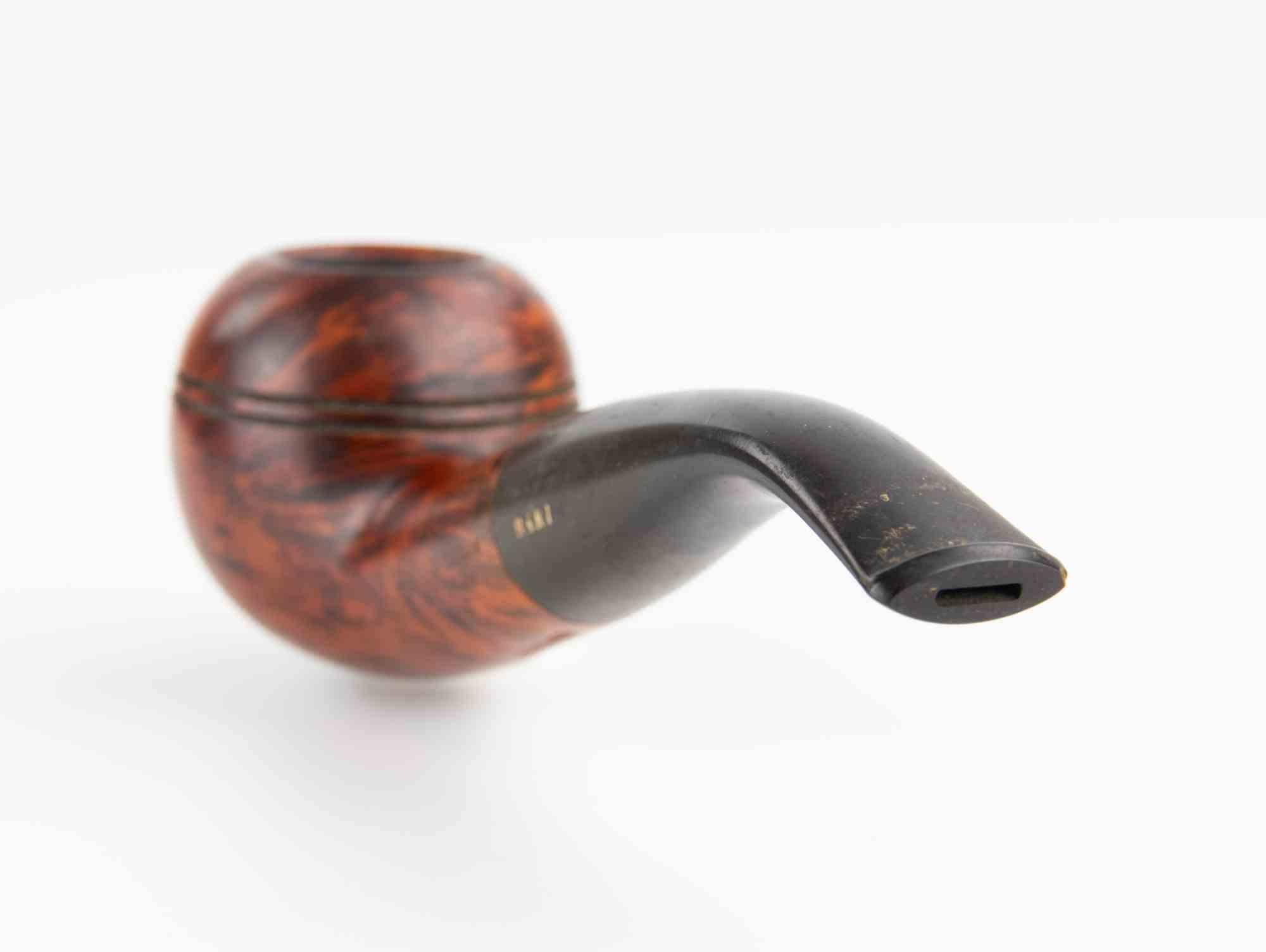 Une élégante pipe danoise de Bari, modèle Mandarin, fabriquée en bruyère fine avec une finition chaude de couleur brun-rouge qui met en valeur le grain naturel du bois. Le bol arrondi présente un double anneau décoratif incisé près du bord, un