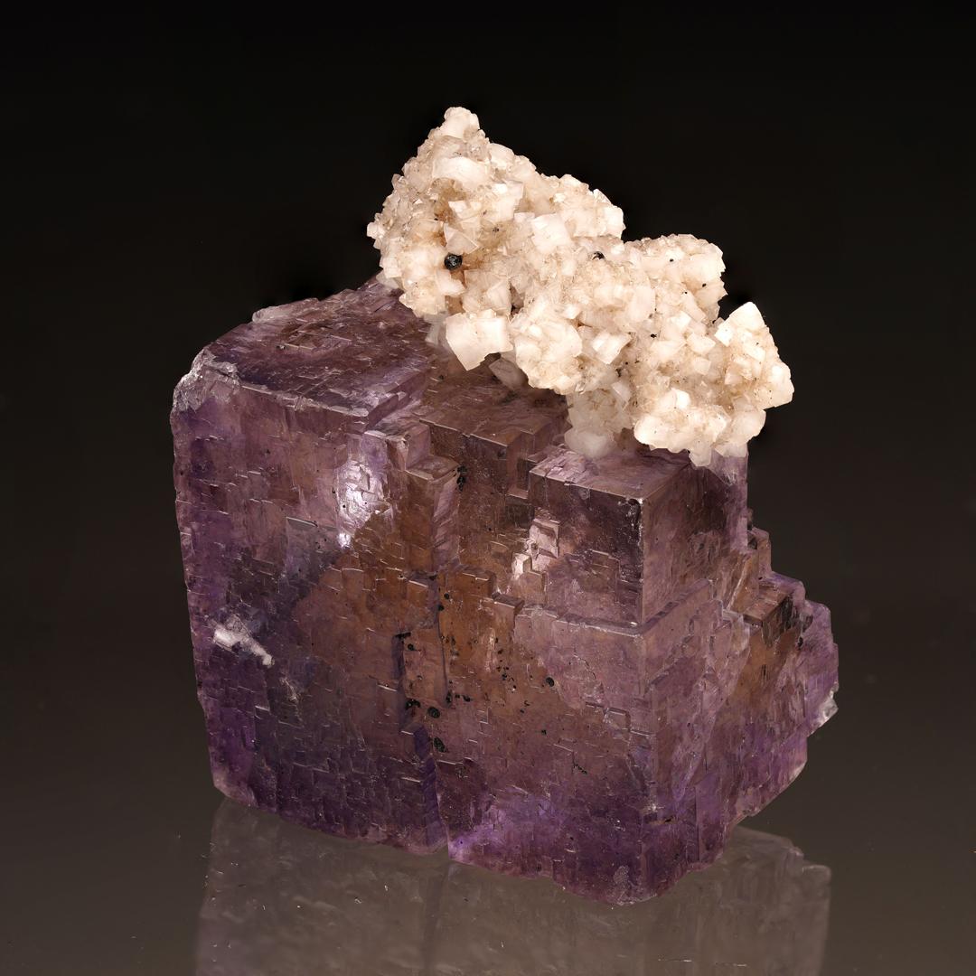 This translucent, lustrous offering of cubically formed purple fluorite out of Elmwood, TN is decorated with outcroppings of sparkling, textured barite for a unique and visually arresting presentation. A fabulous arrangement for the discerning