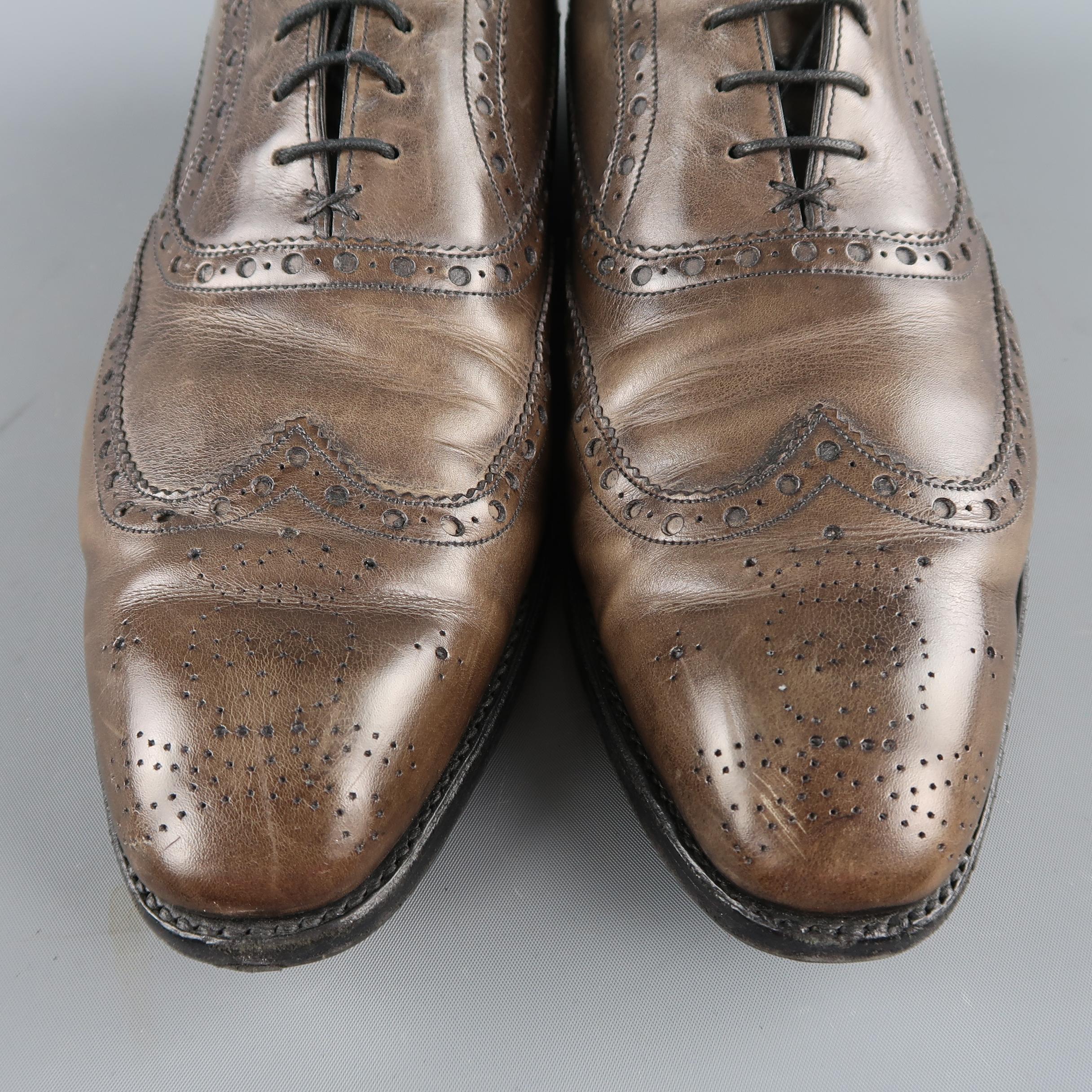 BAKER BLACK ARCHDALE brogues come in taupe gray leather with perforated piping and wing tip with skull crossbones medallion. Made in England.
 
Good Pre-Owned Condition.
Marked: 10
 
Outsole: 12 x 4 in.