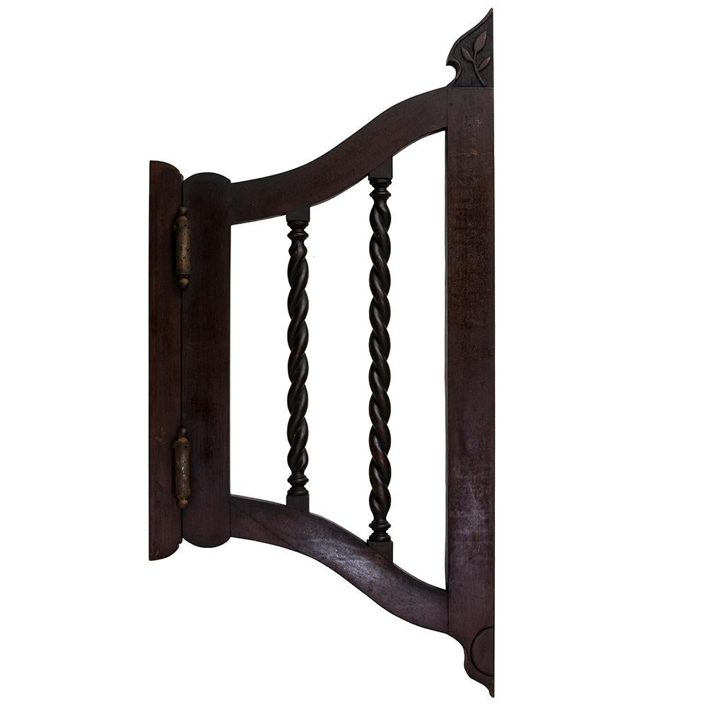 These early and unusual saloon doors are made from solid walnut. Their graceful silhouette is accented by an in carved leaf at the inner crest of each door and the elegant barley twist stiles in the center. Later 19th century.