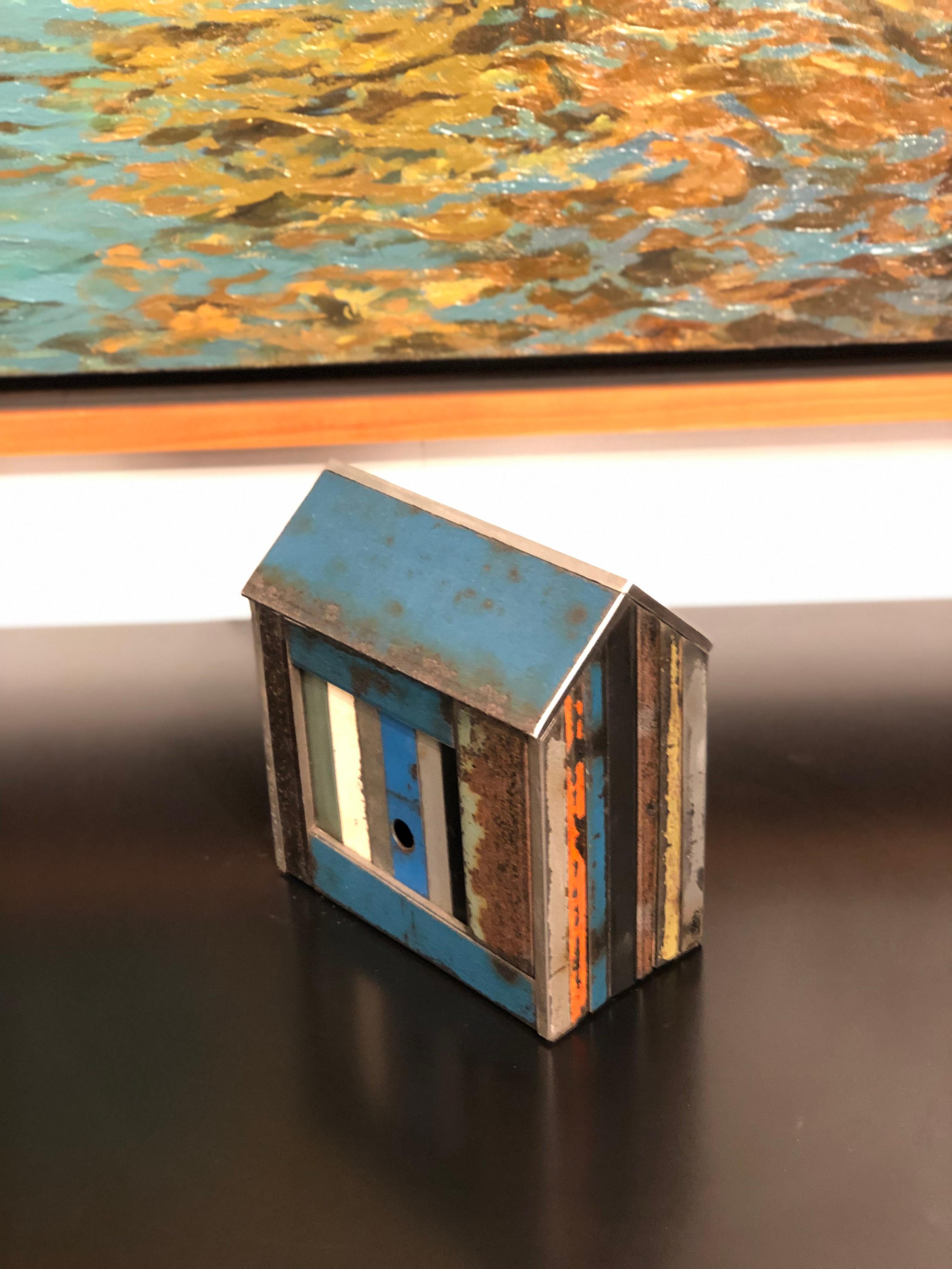 This is a welded steel sculpture made by furniture creator Jim Rose. It is created from salvaged steel panels left over from his larger projects. These sculptures reference traditional American Folk Art barn house models or bird houses. This