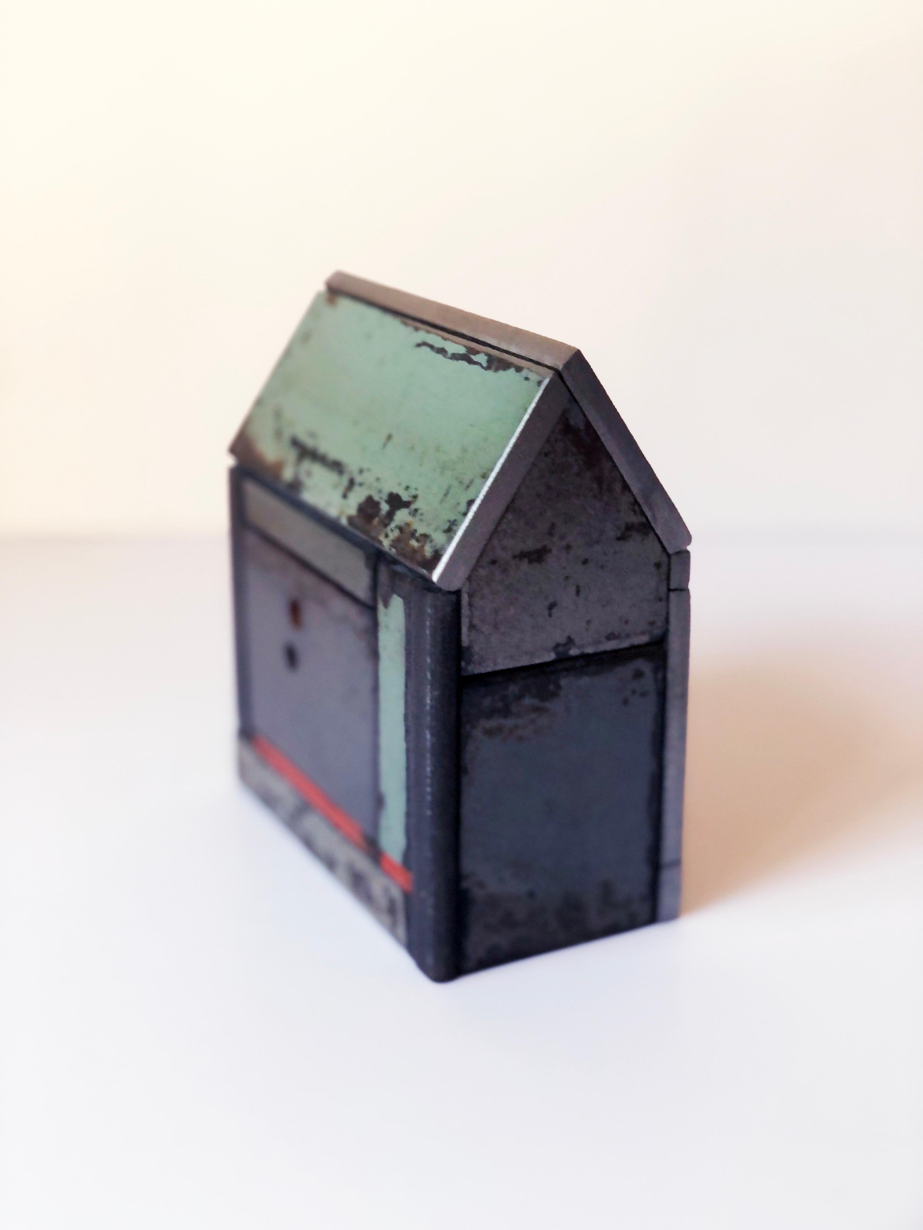 This is a welded steel sculpture made by furniture creator Jim Rose. It is sustainable design created from salvaged and recycled steel panels left over from his larger projects. These sculptures reference traditional American Folk Art barn house