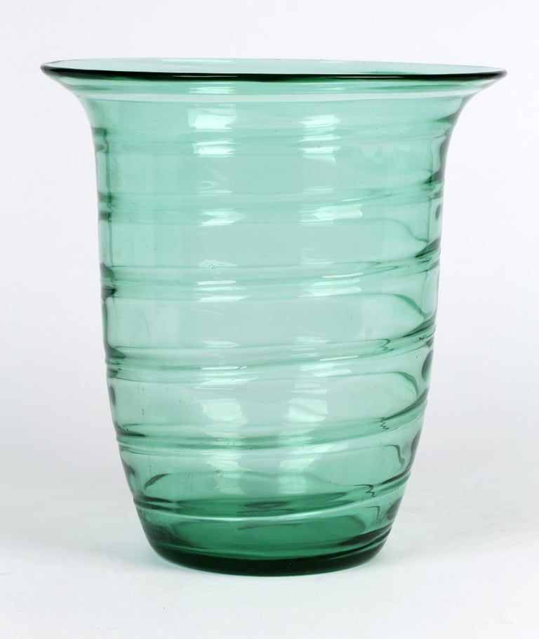 A stunning and large English whitefriars glass green ribbon twist art glass vase designed by Barnaby Powell and dating from the 1930's. The large bucket shaped vase has a narrow rounded flat base with a cylindrical shaped body and everted rim with a