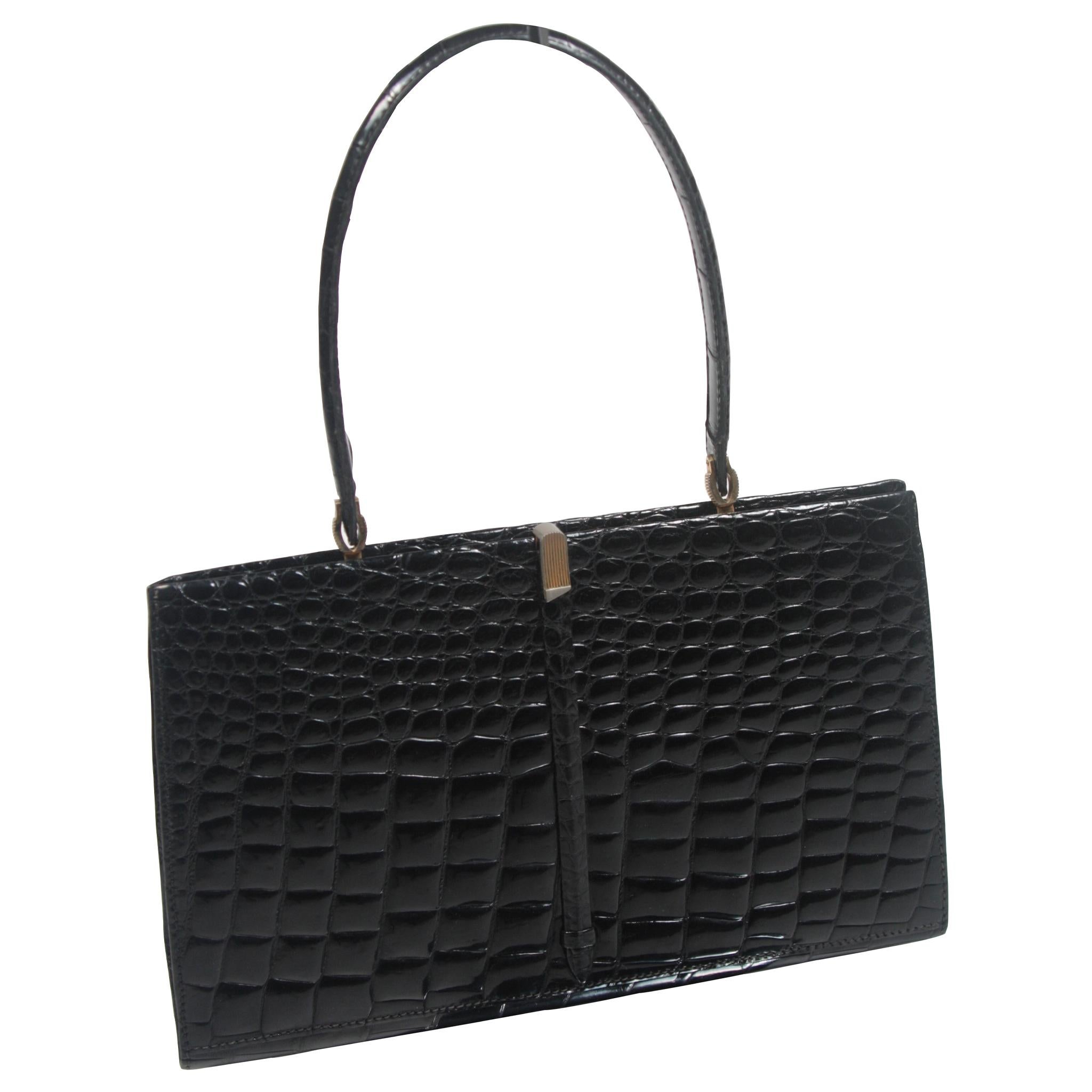 This Barnes Shoe Salon handbag is composed of a striking beautiful black Crocodile. It features gold hardware and interior compartments. In excellent vintage condition. Made in France. 

**Please cross-reference measurements for personal accuracy.