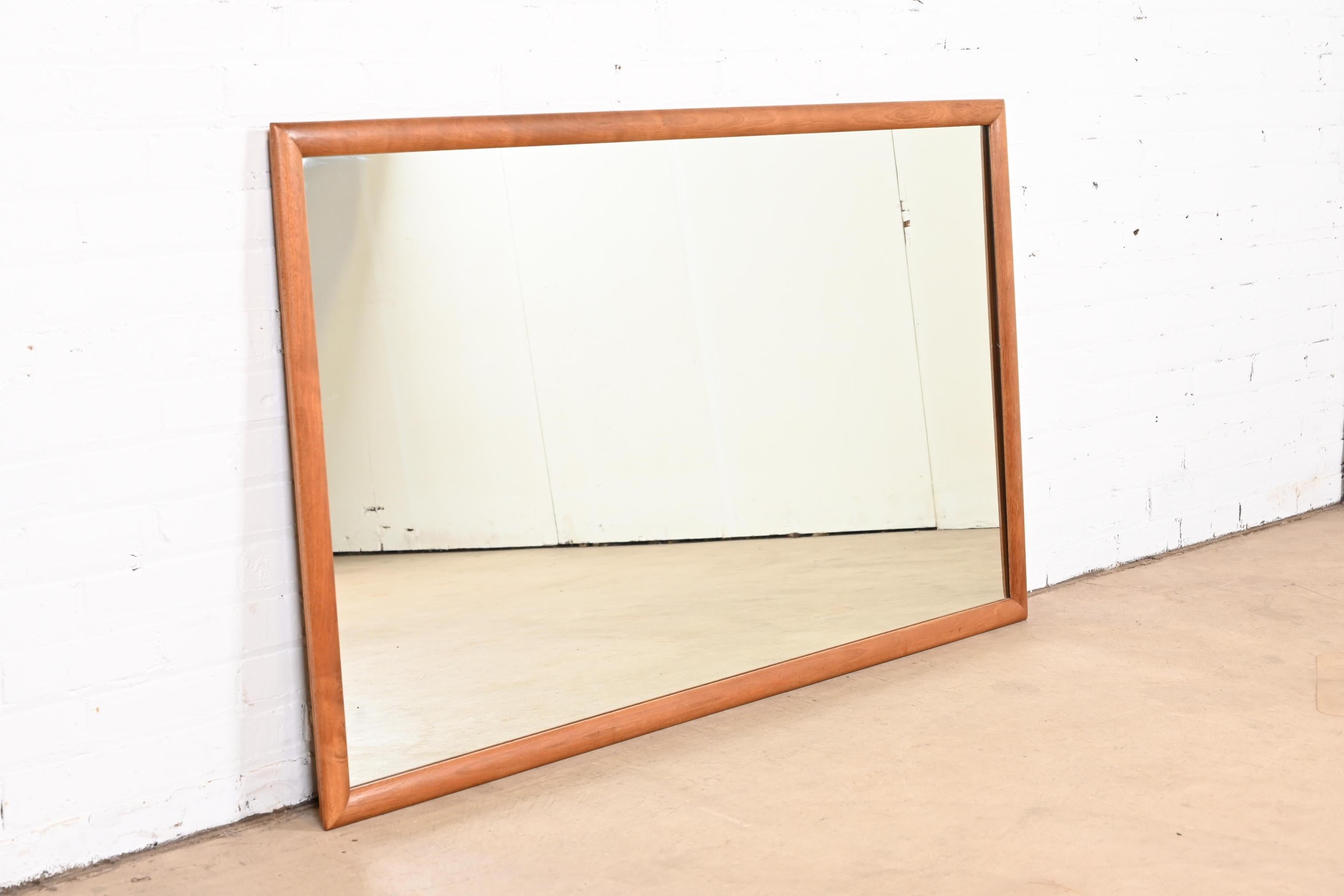 A stylish Mid-Century Modern sculpted cherry wood framed large mirror.

By Barney Flagg for Drexel, 