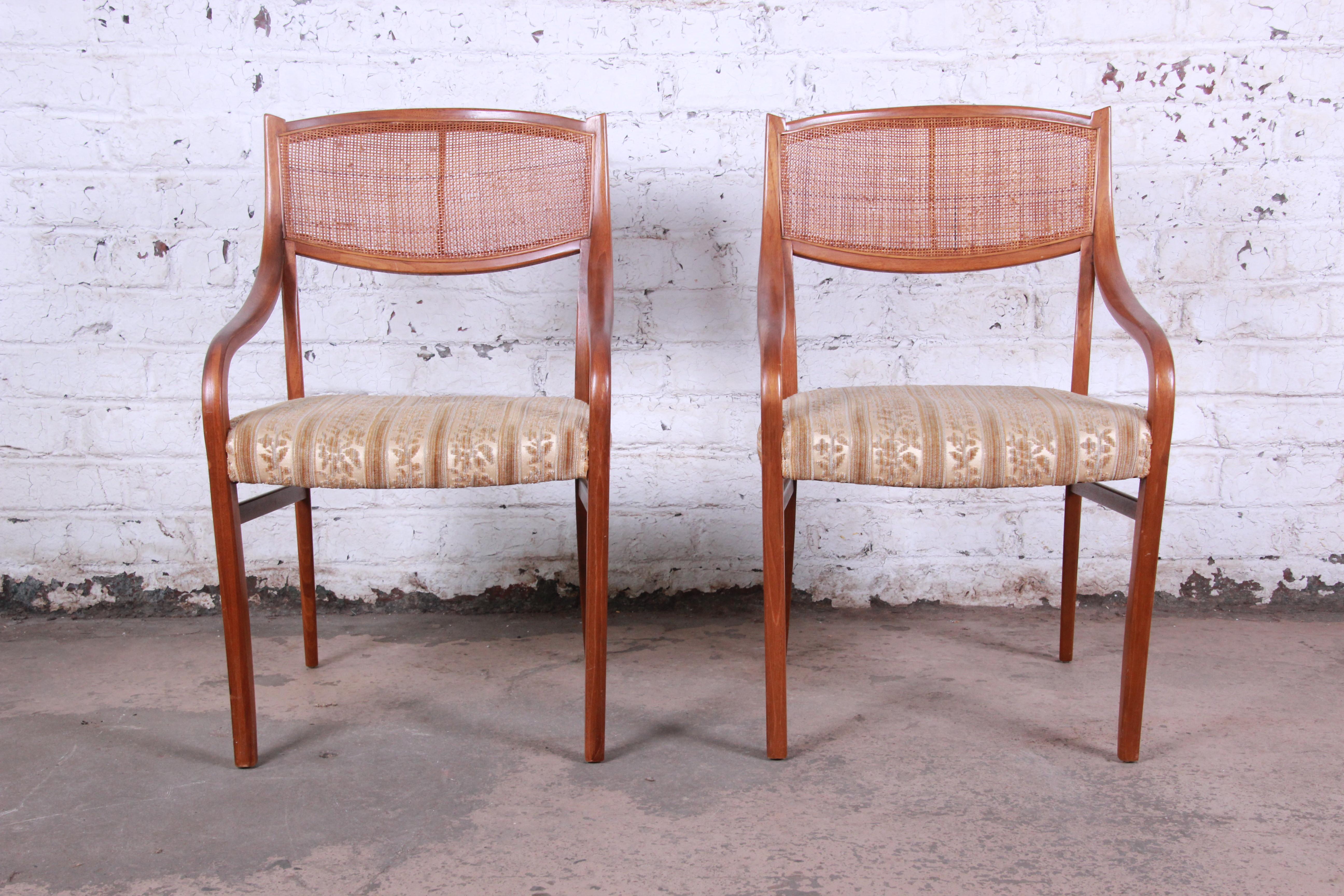 A rare and excellent pair of Mid-Century Modern walnut and cane armchairs designed by Barney Flagg for Drexel, circa 1960. The chairs feature gorgeous sculpted walnut frames, with caned seat backs. The original floral upholstery is clean and ready