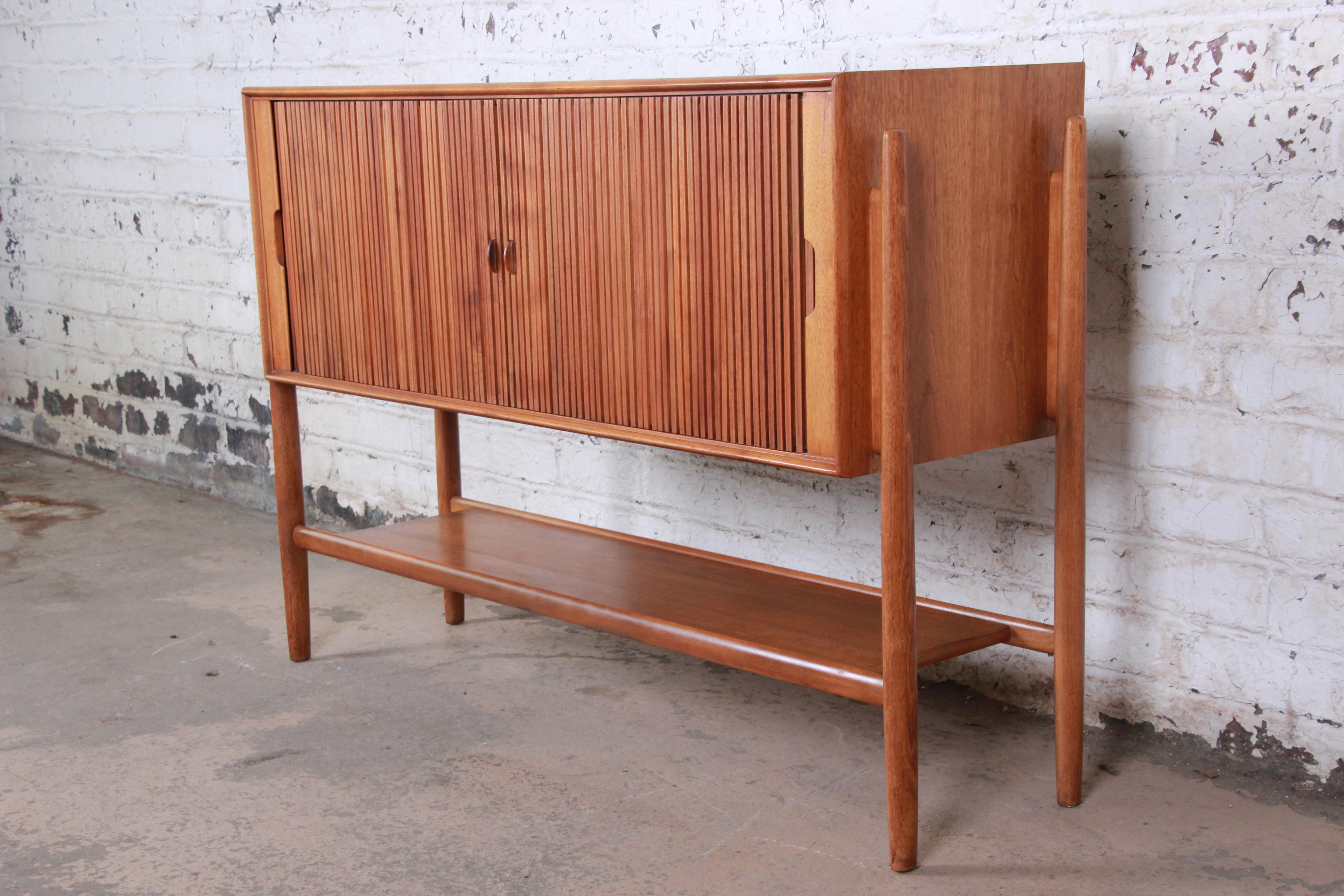 A rare and exceptional Mid-Century Modern walnut tambour door sideboard or credenza designed by Barney Flagg for the Parallel line by Drexel. The credenza features gorgeous walnut wood grain and sleek Danish-inspired design similar to pieces by Arne