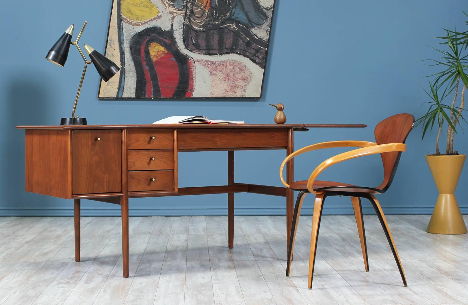 Writing desk designed by Barney Flagg for Drexel’s Parallel line and manufactured in the United States circa 1960’s. This Mid Century modern classic desk is made of walnut wood with a drop-down leaf to add surface area. The desk features five