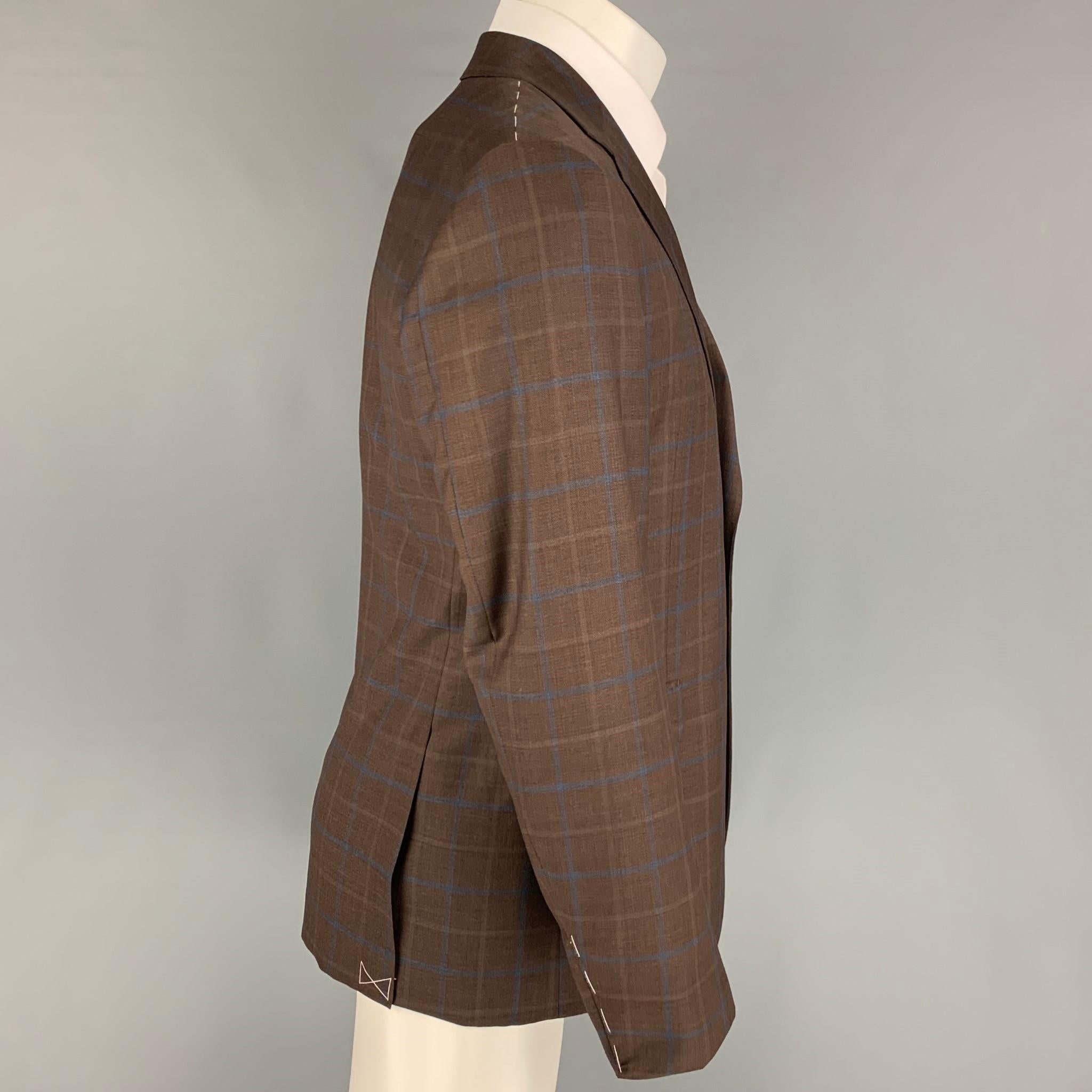 BARNEY'S NEW YORK sport coat comes in a brown & navy plaid wool / silk with a half liner featuring a notch lapel, flap pockets, double back vent, and a double button closure. Comes with tags.

Excellent Pre-Owned Condition.
Marked: