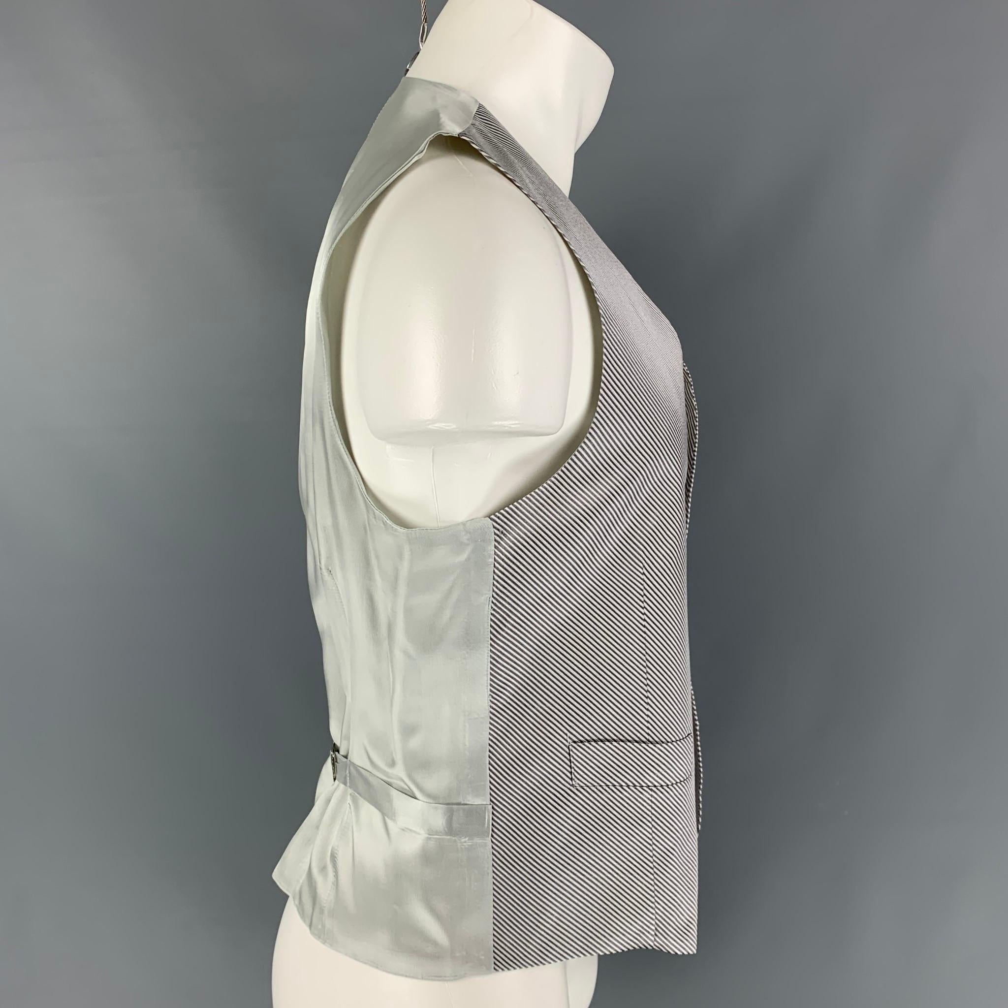 BARNEY'S NEW YORK vest comes in a silver diagonal stripe silk featuring a back belt, front pockets, and a buttoned closure. Made in Italy. 

Very Good Pre-Owned Condition.
Marked: 40

Measurements:

Shoulder: 14 in.
Chest: 40 in.
Length: 23 in. 