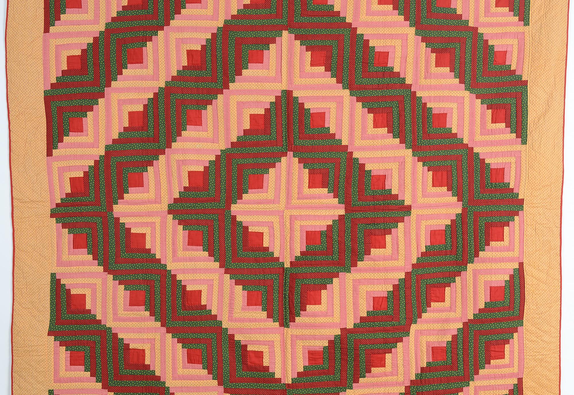 This is a very striking example of a classic Barnraising Log cabin quilt. The fabrics are prints with the exception of the red centers that really 