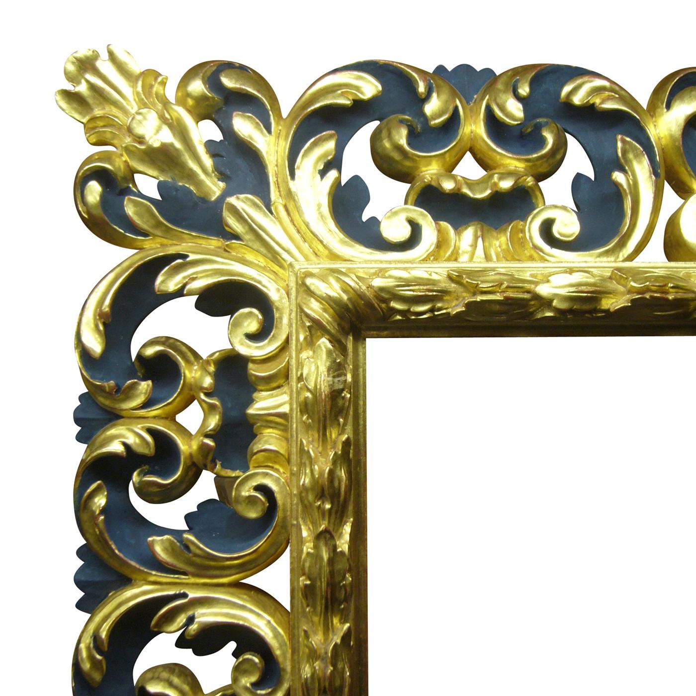 This is a Baroque mirror in pinewood finished in gold and color. The frame is hand-carved with characteristic scrolls and leafs. Its simple shape and beautiful detail make it an ornate piece of decor. It comes with a mirror with an antique finish.
 