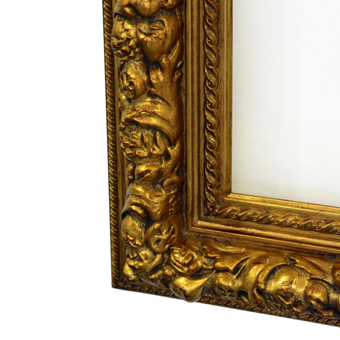 A meticulous and refined work of art by master woodworkers, this magnificent frame boasts a bold Baroque-inspired design entirely crafted and engraved by hand. Glazed with mesmerizing gold leaf, this piece will be a sumptuous and charming addition