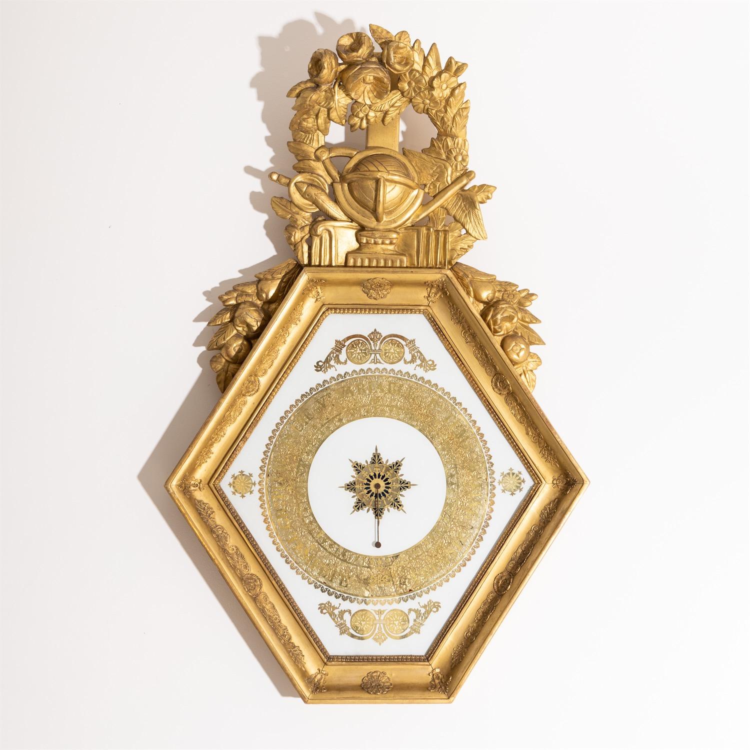 Hexagonal barometer in gold-patinated stucco frame with carved top in the form of flower festoons and central globe motif as an allegory on geography. The dial made of glass with églomisé painting.