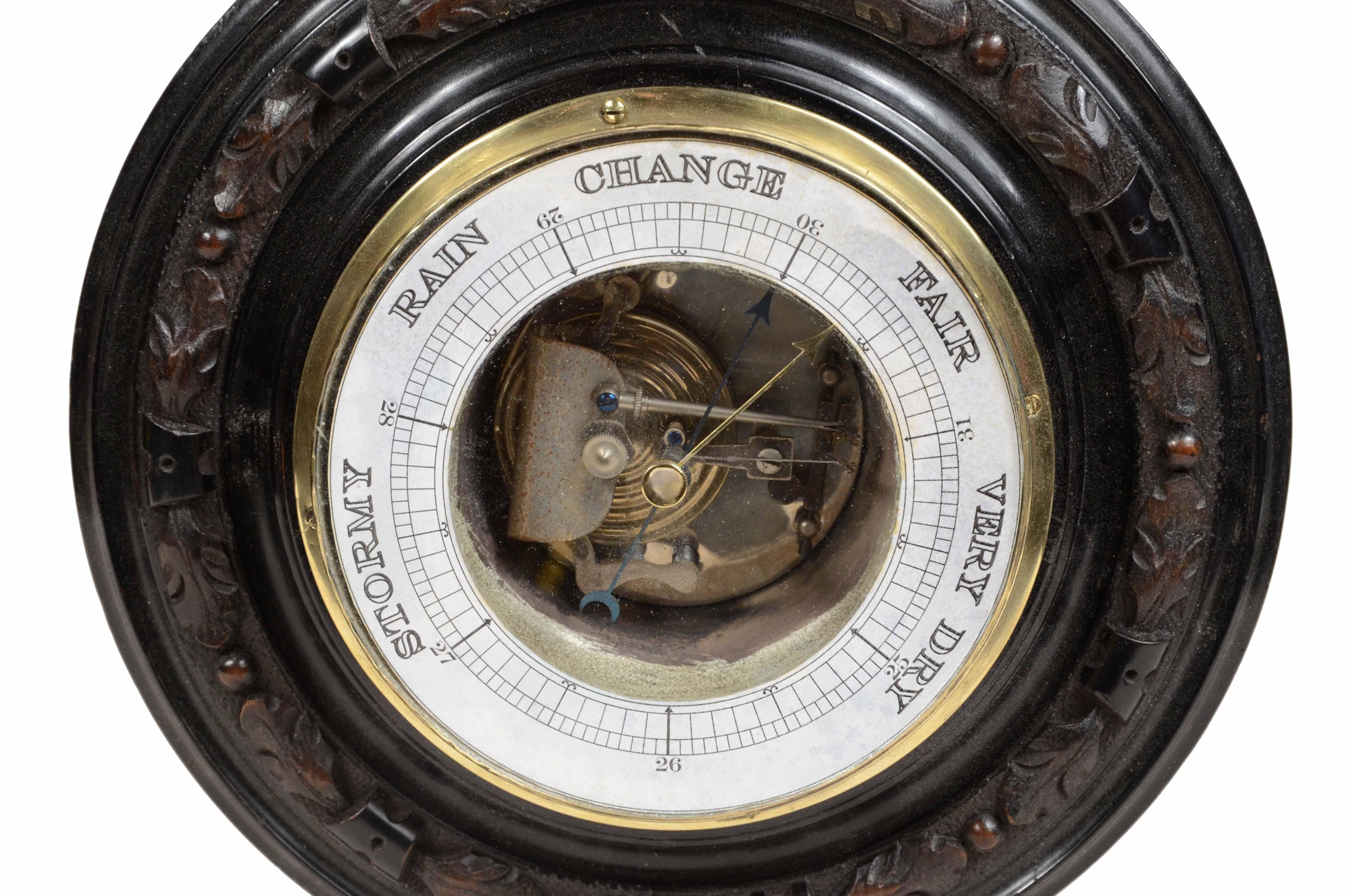 Wall-mounted aneroid barometer made of carved wood, brass, and glass, an instrument whose pressure-sensitive organ is a metal box called a barometric capsule. 
English manufacture of the late 19th century. 
Good condition, working.
Diameter cm 23.3