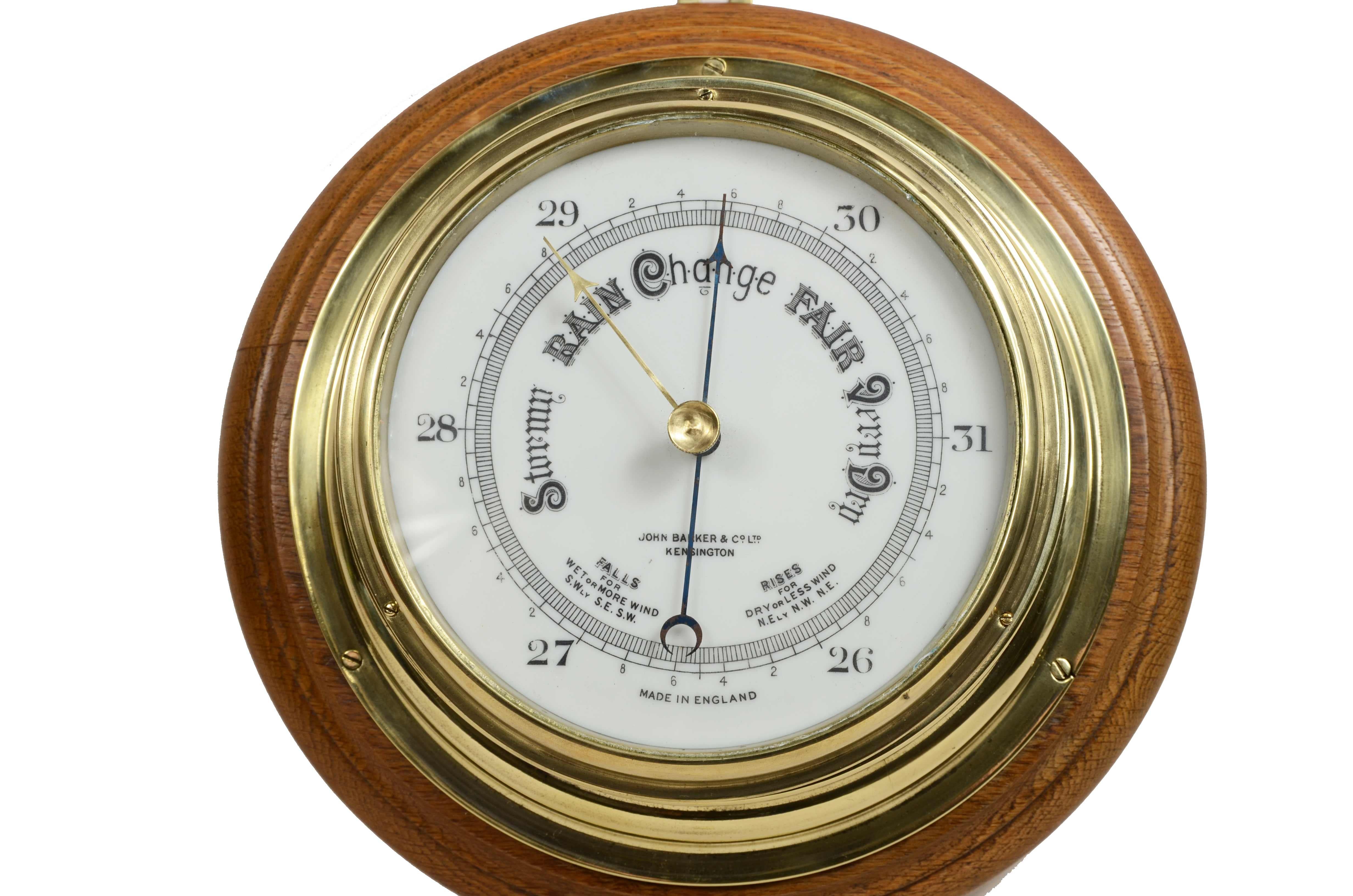 Brass and glass wall-mounted aneroid barometer mounted on turned oak plank, signed John Barker & Son Ltd Kensington. This is an instrument whose pressure-sensitive organ is a metal box called a barometric capsule. 
English manufacture of the early 