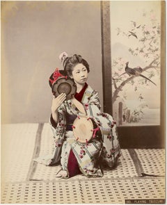 A Maiko playing Tsudzumi (Young geisha playing the hand-drum)