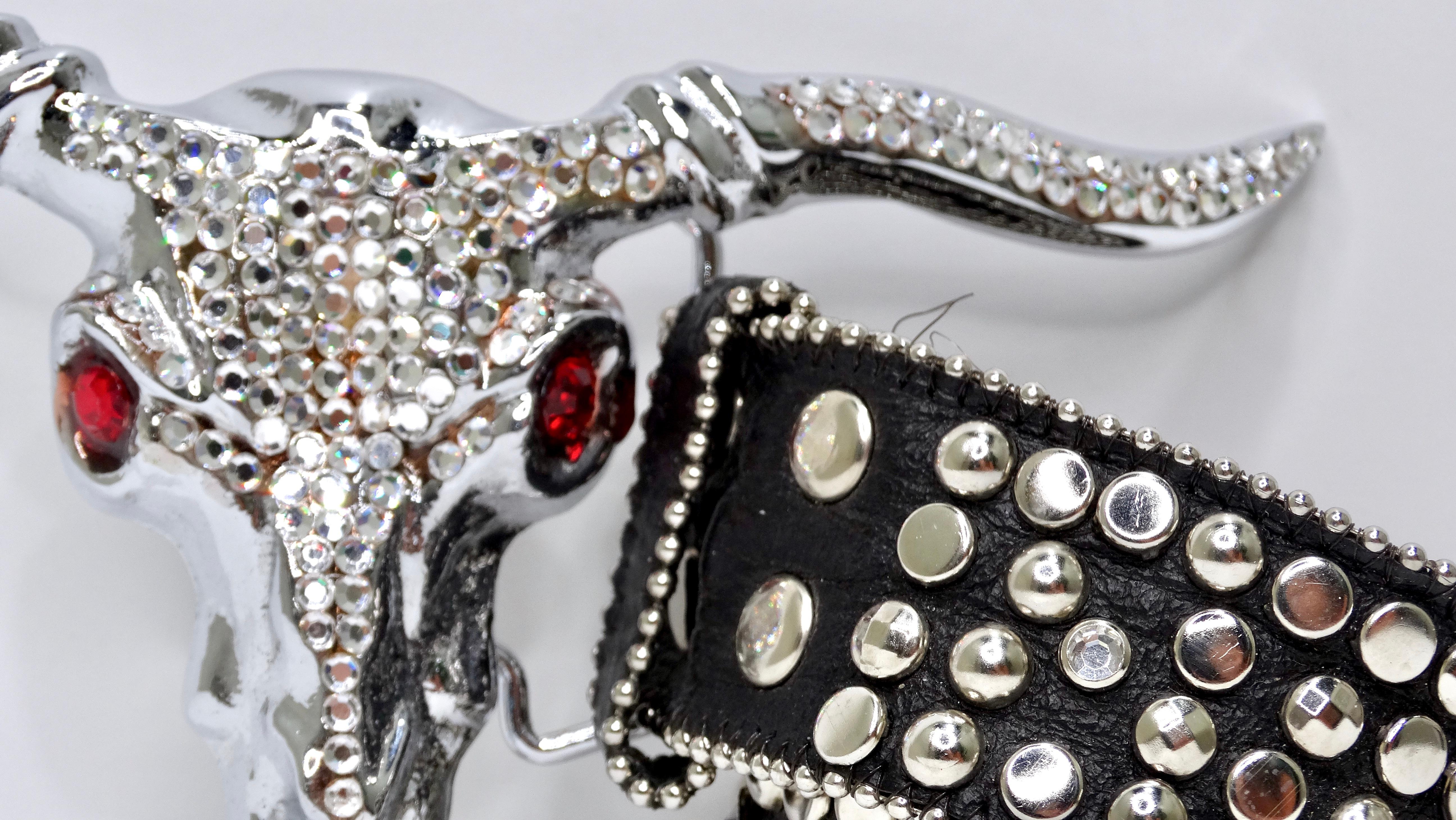 Add some edge to your everyday western belt! This intricately designed belt buckle depicts a longhorn steer skull completely adorned with clear crystals and red crystals for eyes. The belt is highly detailed with silver metal studs lining the entire