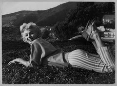 Vintage Sweet and laughing Filmstar Marilyn Monroe is laying on the green, 1954