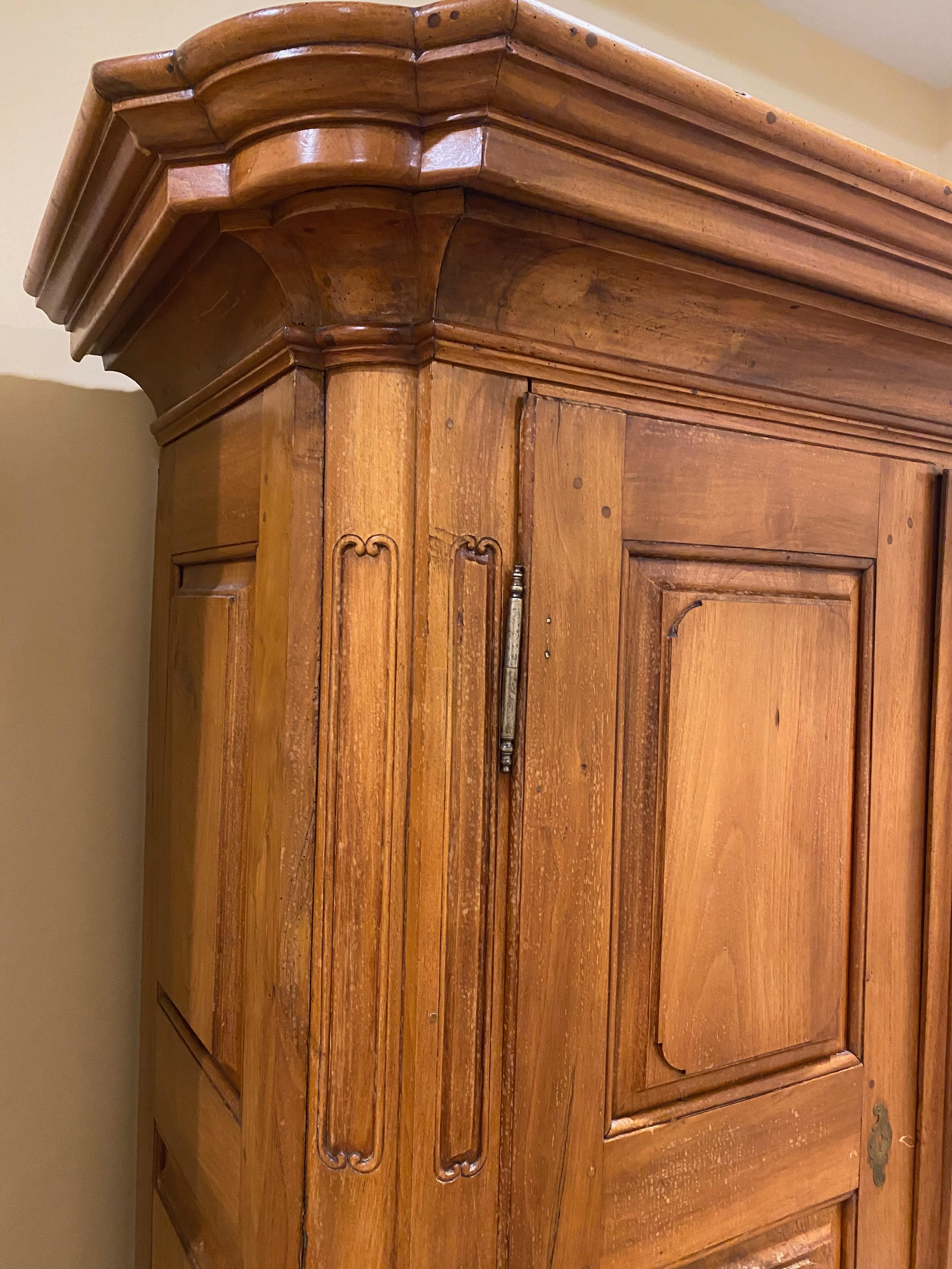 This original Baroque armoire stands out for its exquisite hand-carved details. It dates back to 1750 and was made in southern Germany. 
The two door armoire is made of massif walnut. The protruding cornice and base are beautifully designed. Sides