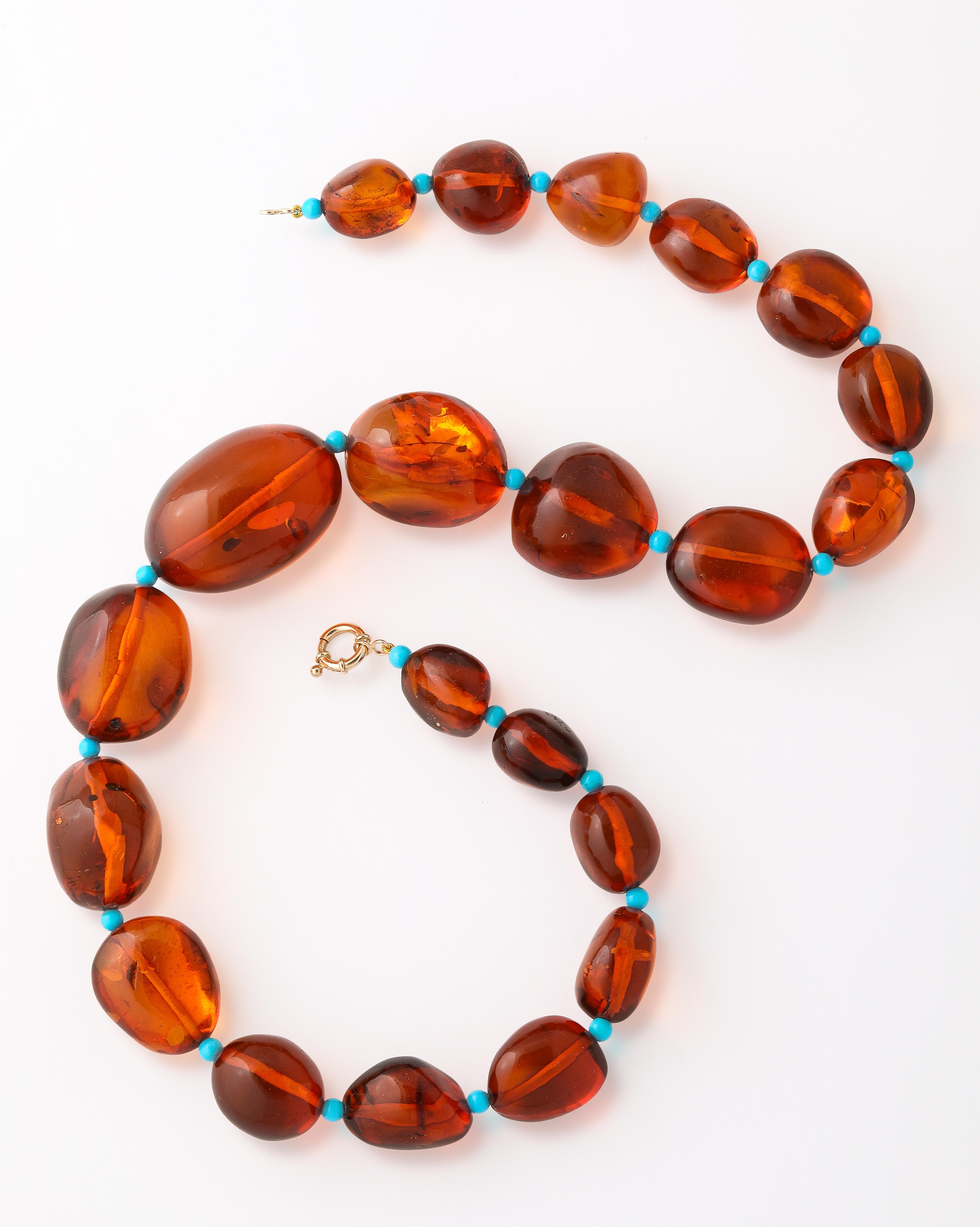 A chic and striking composition, this 23-inch necklace features a captivating arrangement of baroque-shaped Baltic amber beads ranging in size from 16mm to an impressive 40mm. The warm, golden tones and natural inclusions of the amber beads are