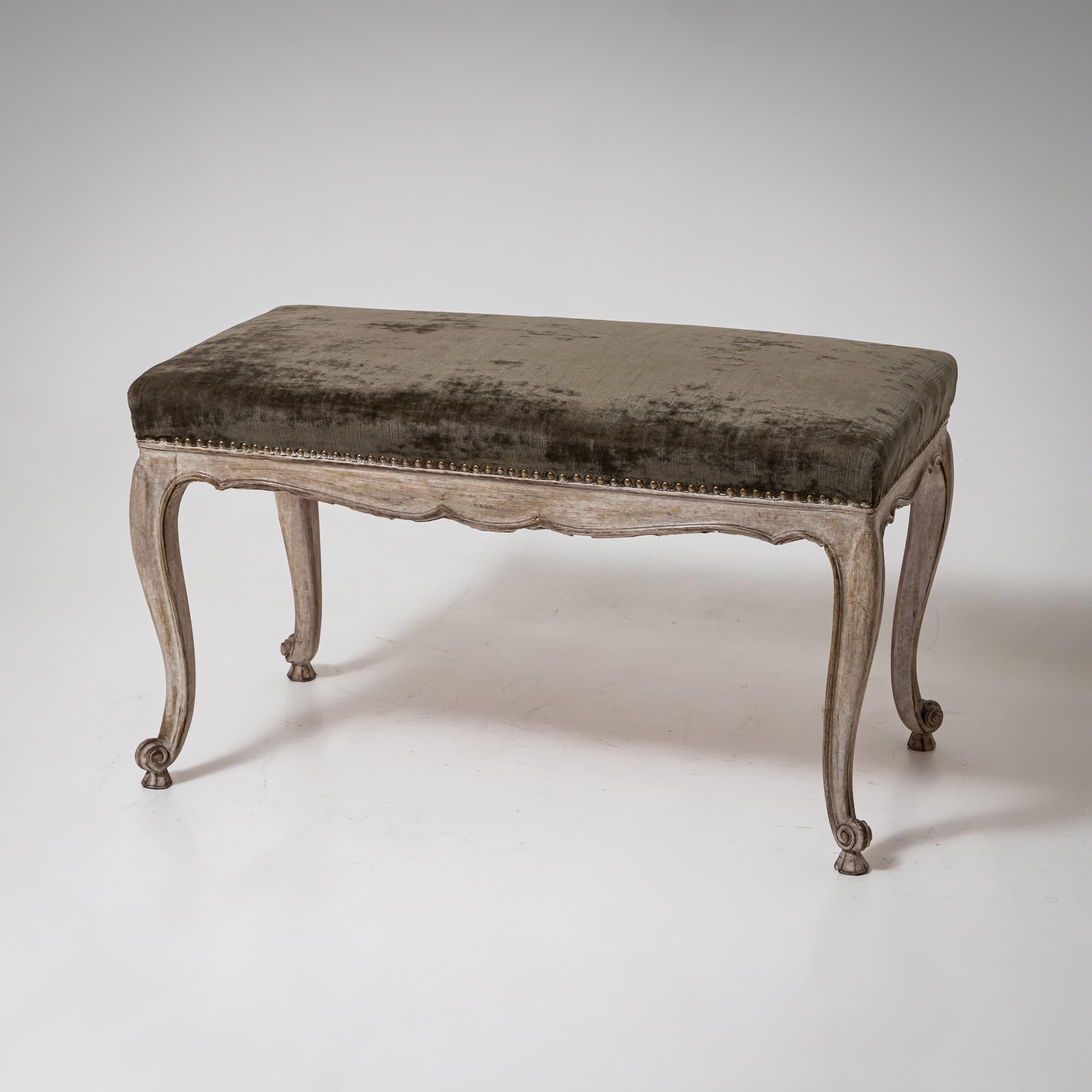 Elegante Barockbank oder großer Hocker aus dem 18. Jahrhundert, mit anmutig geschwungenen Beinen und fein geschnitzten Details. Die neu aufgetragene graue Lackierung mit einer authentischen Patina unterstreicht den historischen Charme des Stücks.