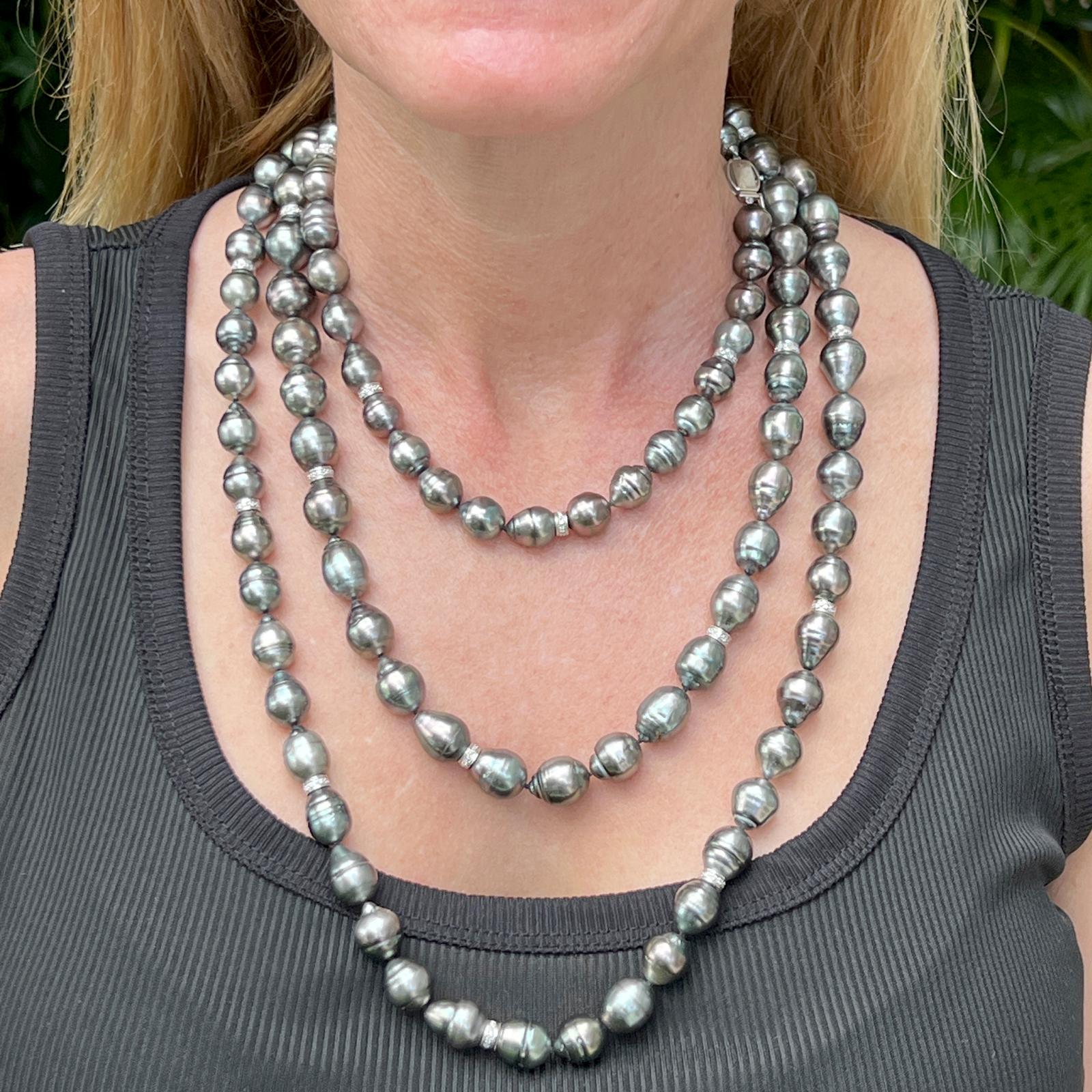 Beautiful long strand of black baroque pearls with diamond rondells. The 64 inch necklace features black baroque pearls intersperced with diamond rondells weighing approximately 1.00 carat total weight. The necklace can be worn multiple ways and has