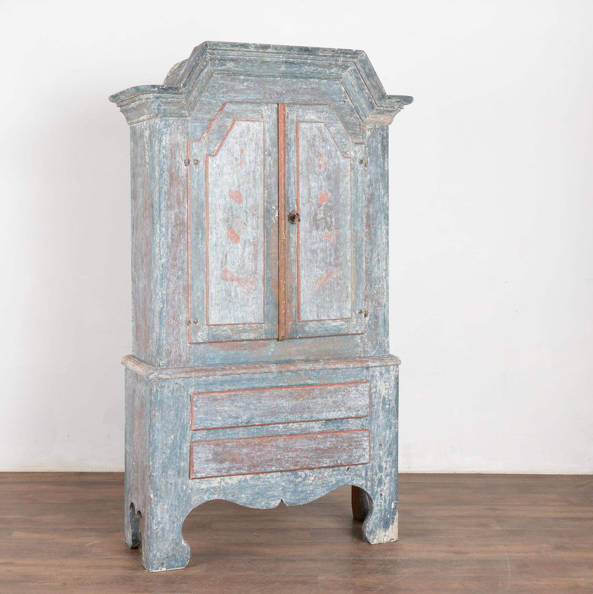 Lovely Swedish baroque cabinet from the early 1800's with original blue and red accent painted finish. The old painted finish has been scraped to reveal the soft, warm aged patina of the pine and residual white undertones.
Note the traditional