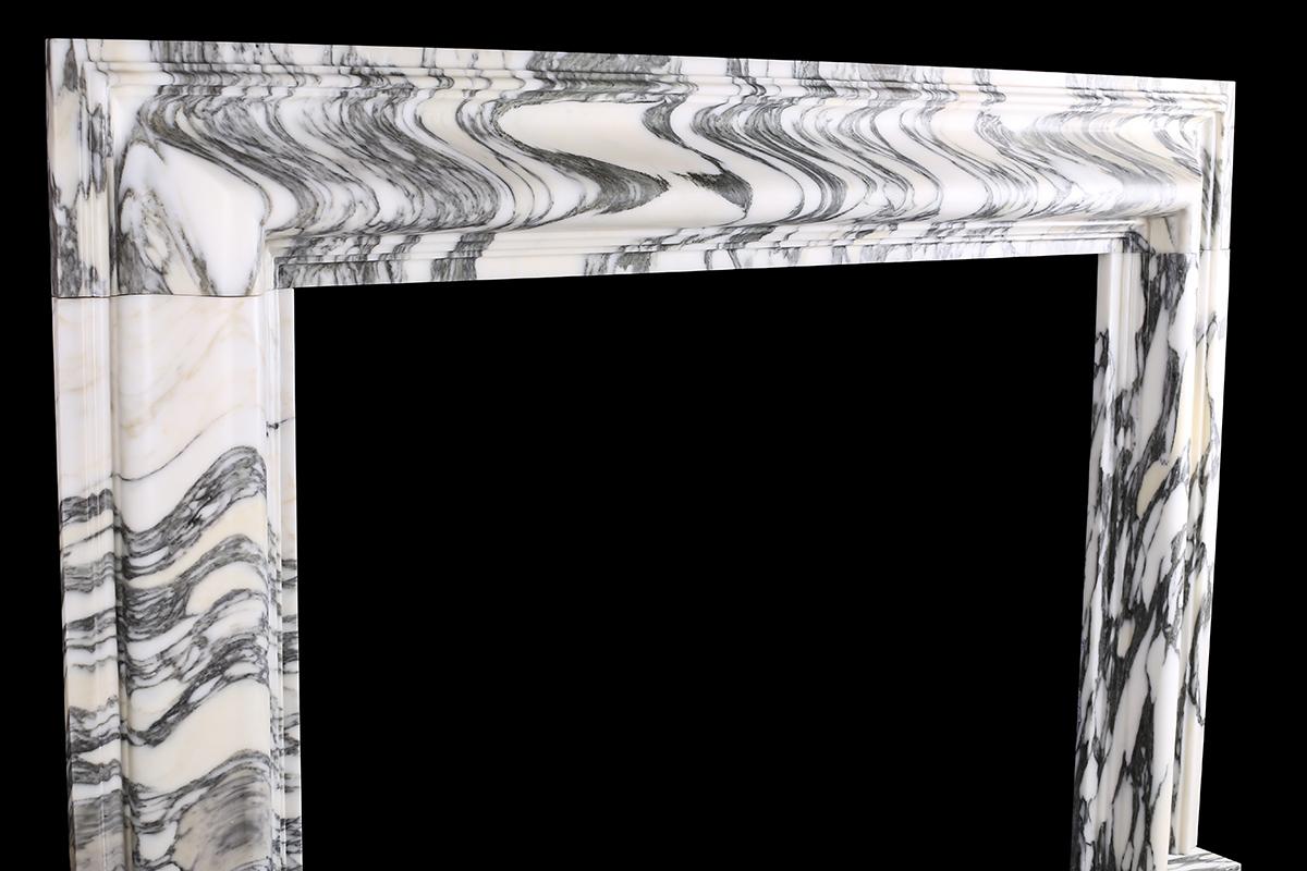A Baroque Bolection fireplace in Italian Arabescato marble.

A Baroque style Bolection fireplace surround of bold proportions with very finely carved columns with a rising ogee edging, which are supported on substantial footblocks, in high quality