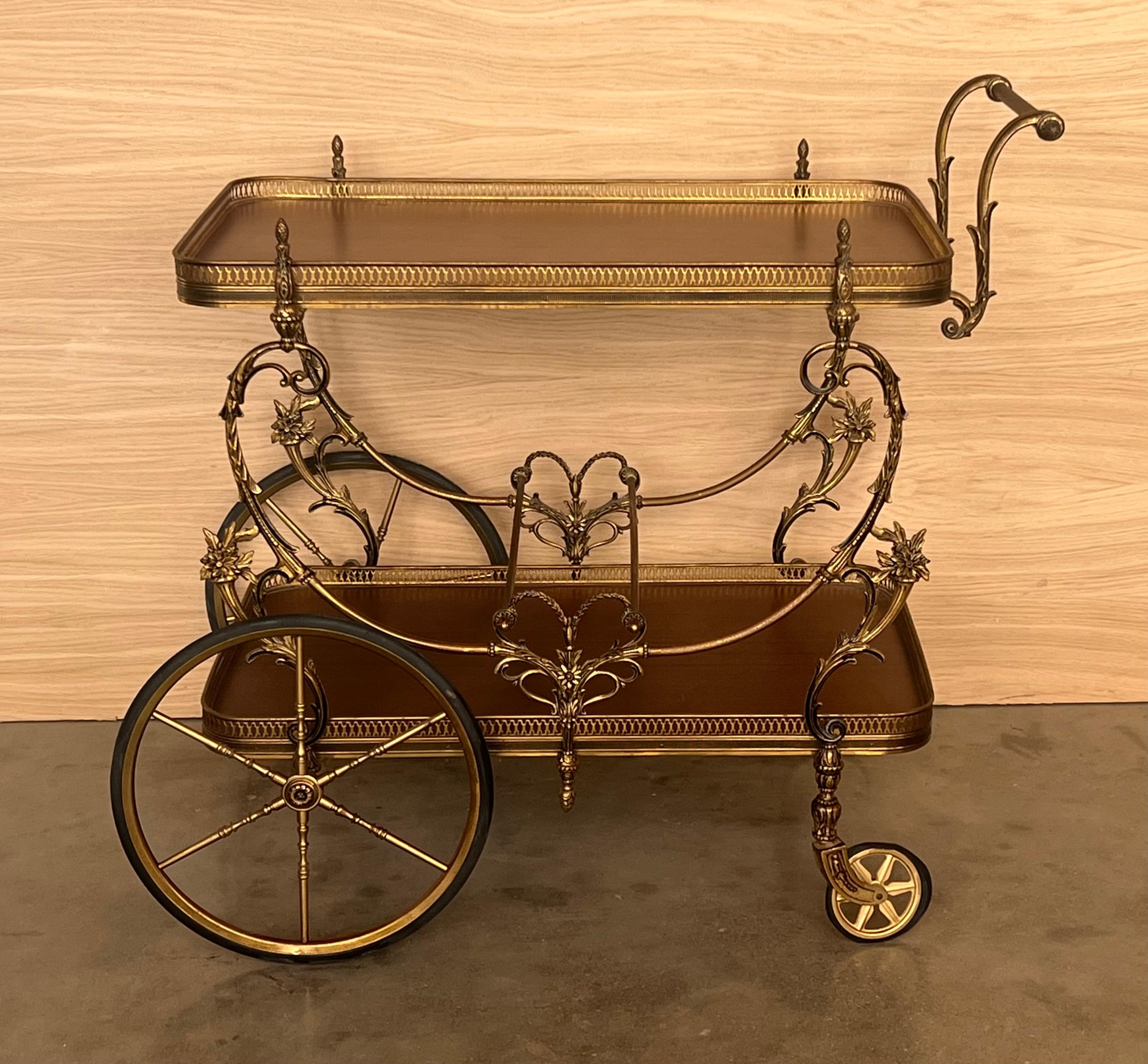 Gorgeous bronze Baroque 2 tier bar or tea cart. under the with wood shelves. Features a heavy ornate bronze frame on casters wheels.

Measure to the low shelve: 25.29in
Measure to the hight shelve: 7.87in