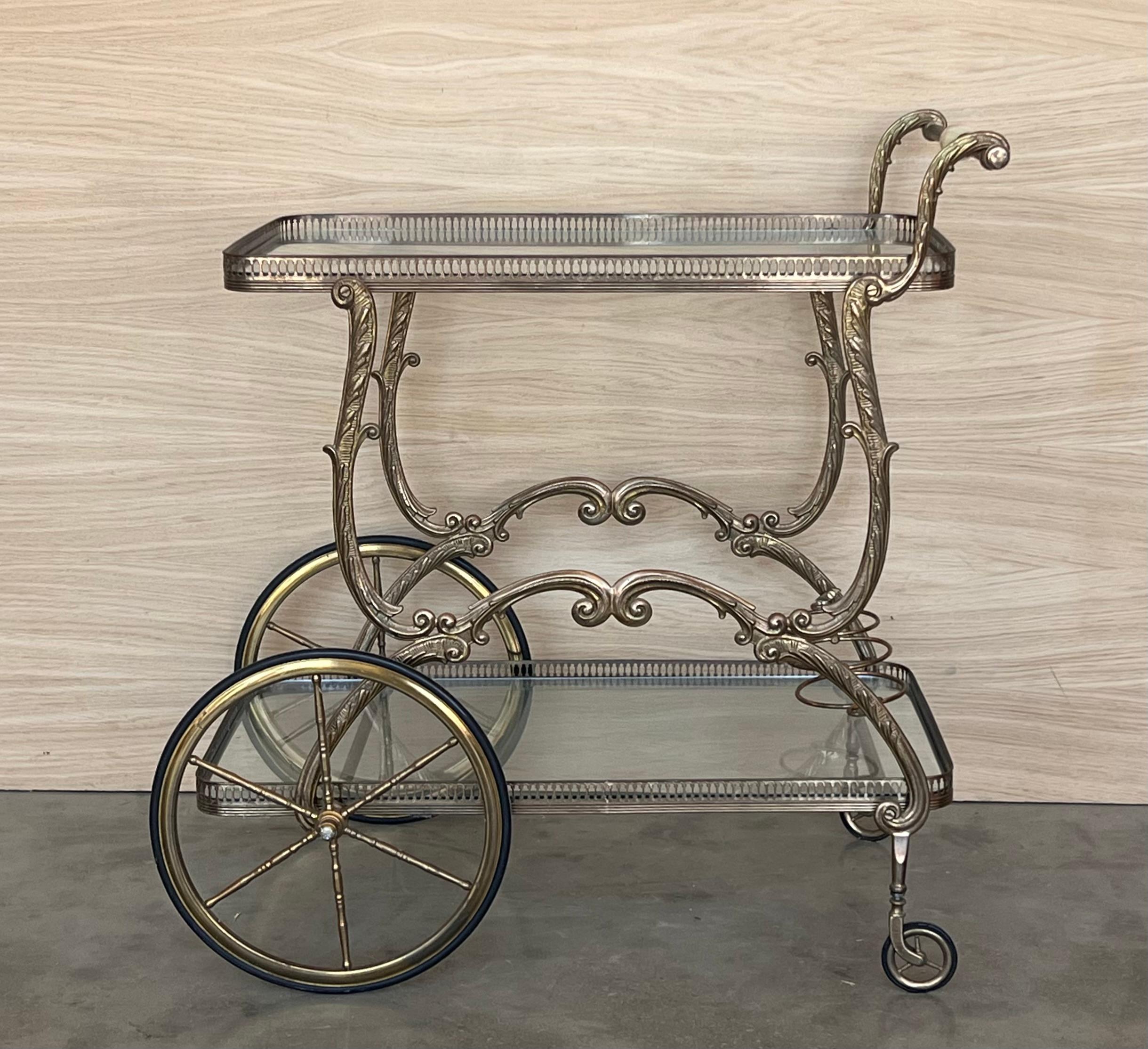 Gorgeous bronze Baroque 2 tier bar or tea cart. under the with wood shelves. Features a heavy ornate bronze frame on casters wheels.

Measure to the low shelve: 6.29in
Measure to the hight shelve: 25.59in