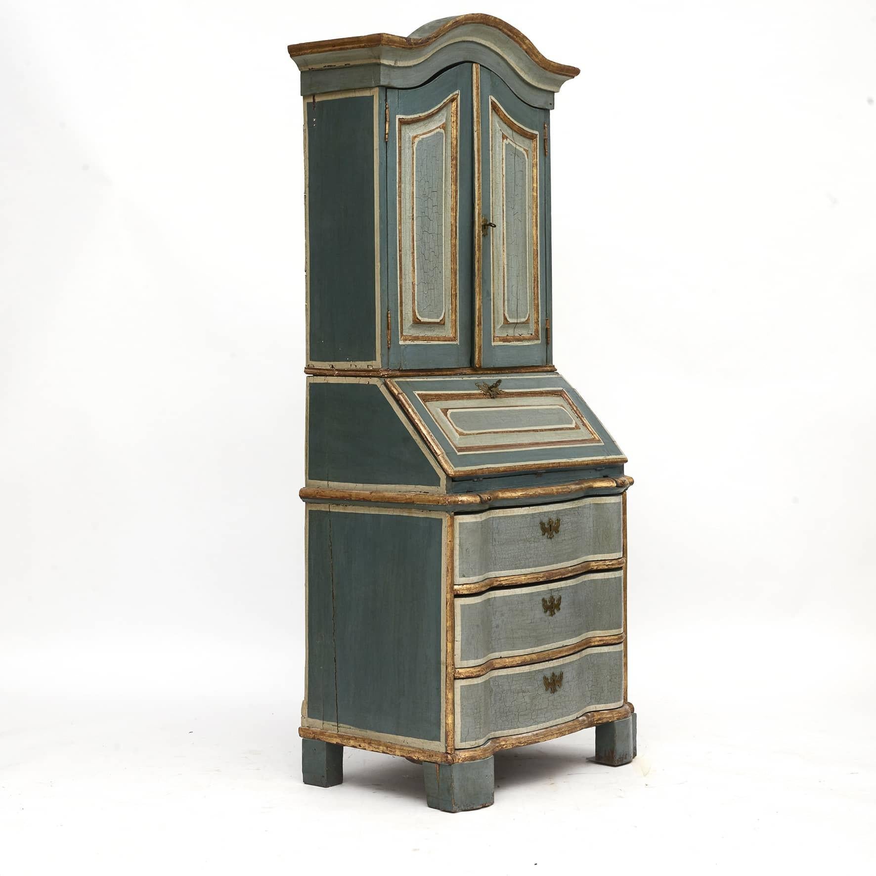 Baroque secretary /bureau in two parts.
Upper cabinet with curved top, pair of doors with marked profiled fillings.
Top of the doors is followed by the top of the bureau.
Bottom with slanted writing flap and marked profile filling.
Small drawers