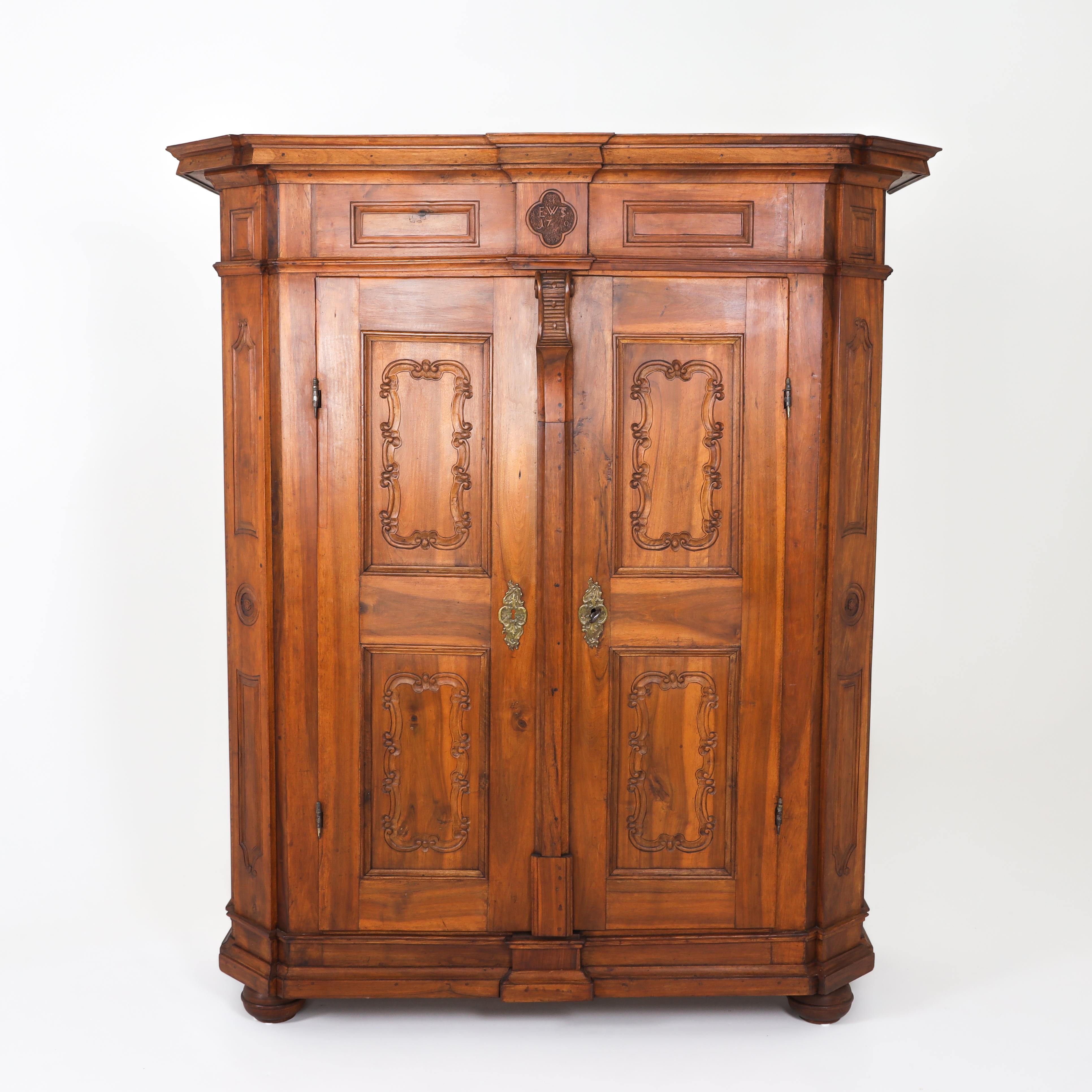 Two-door baroque cabinet with profiled plinth and cornice as well as coffering on all sides. The pilasters are bevelled. A quatrefoil cartouche with monogram EWTS and rubbed date (17#0) rises centrally above a pronounced volute. Very beautiful iron