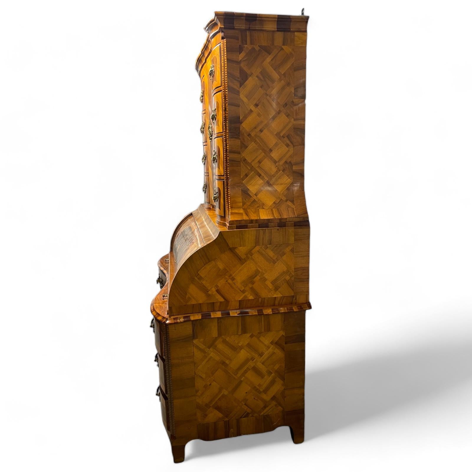 Cabinet baroque avec secrétaire, provenant du sud de l'Allemagne et datant de la fin du 18ème siècle.  En deux parties, la partie supérieure avec une porte à charnière ouvrant sur des étagères de réglage avec quatre tiroirs façonnés flanqués de
