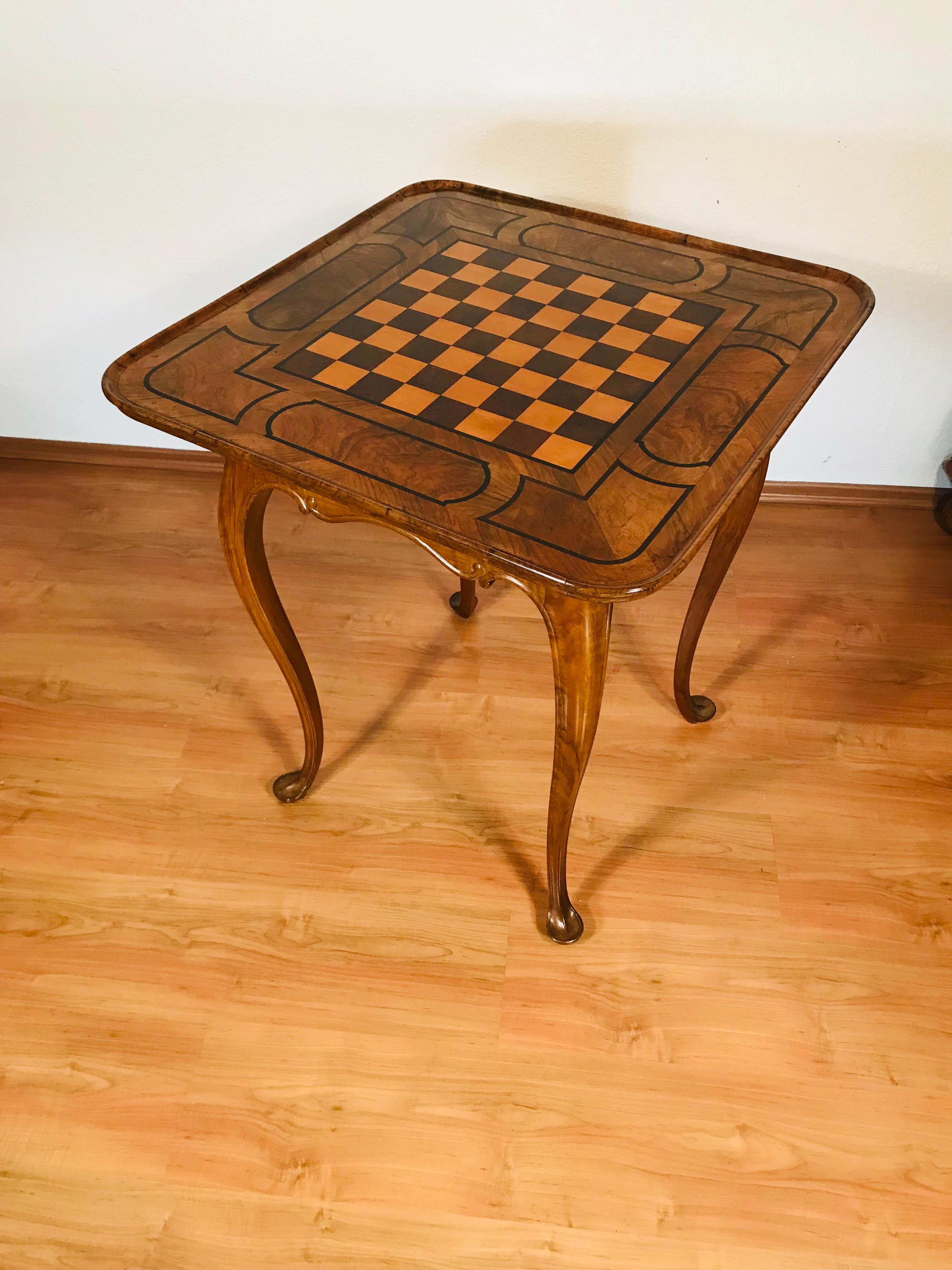 This rare Baroque chess table from Germany, dating to around 1750, combines decorative artistry with timeless functionality. Crafted from solid and veneered walnut, the table showcases the elegance and craftsmanship of the mid-18th century.
The