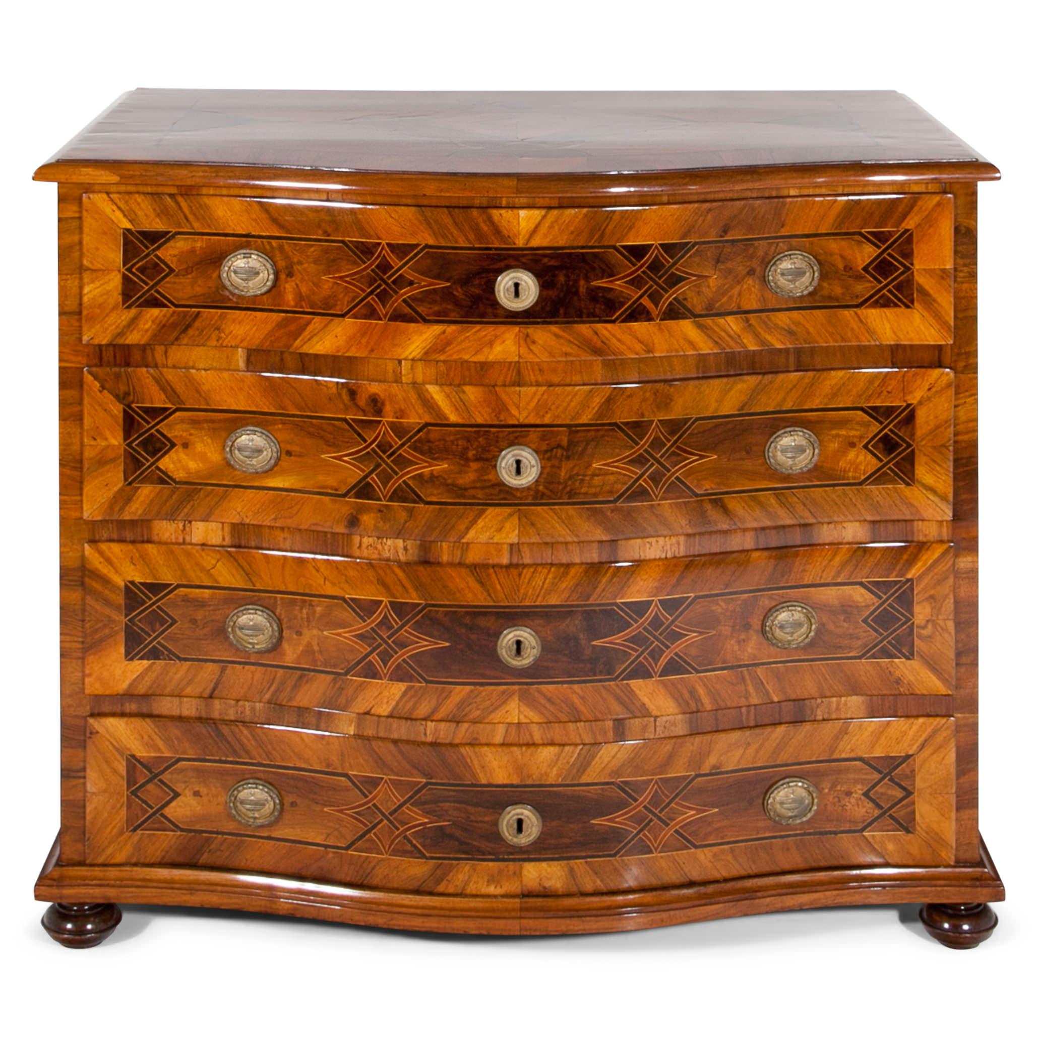 Four drawered Baroque chest of drawers, standing on bun feet. The body shows a bellied front and beautiful strap work marquetry on the drawers.