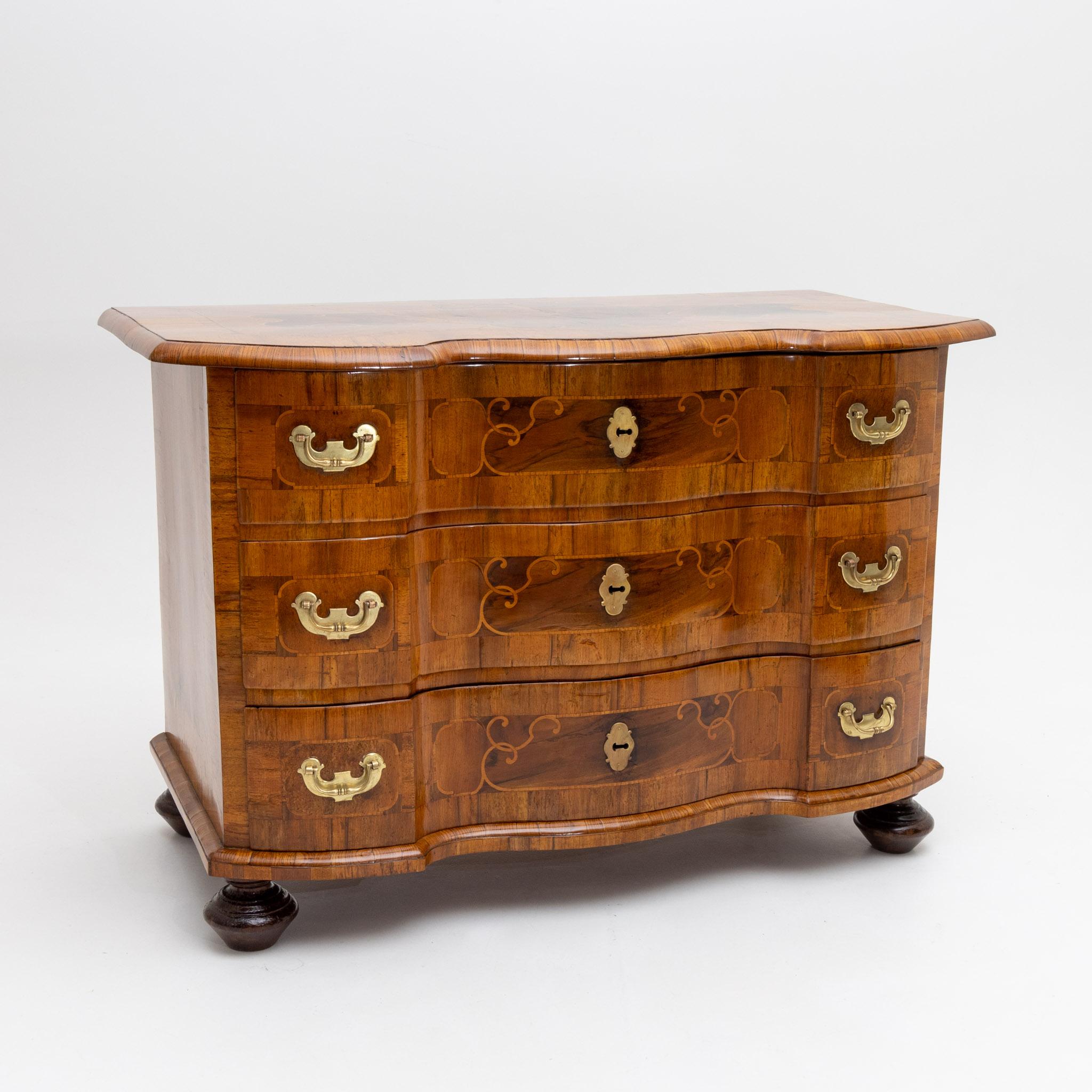 Three-drawer baroque chest of drawers in walnut veneer with ribbon inlays and baluster feet. The chest of drawers is in a restored and hand-polished condition.