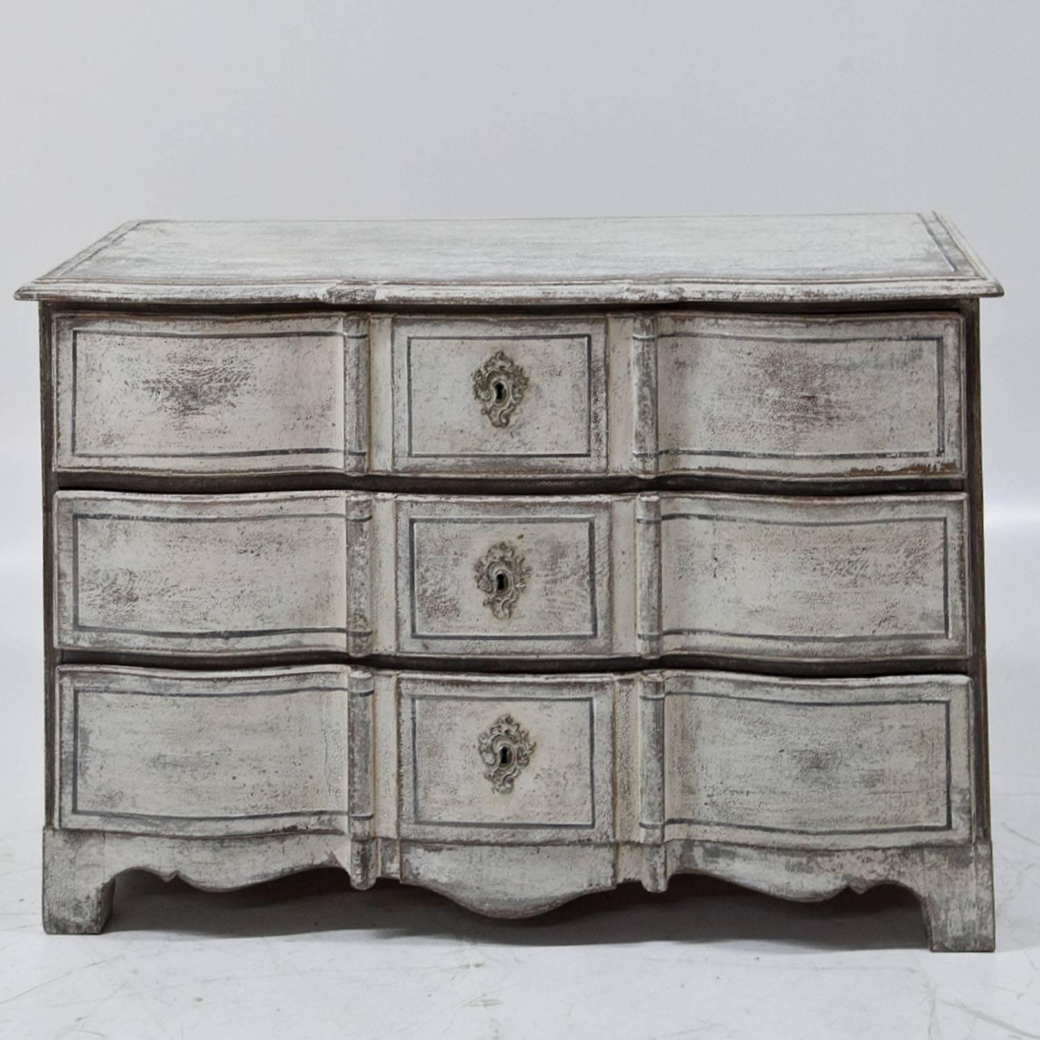 Three-drawered Baroque chest of drawers with a wavy skirt and a serpentine front. The white paint with grey accents is new and has a shabby-chic patina.