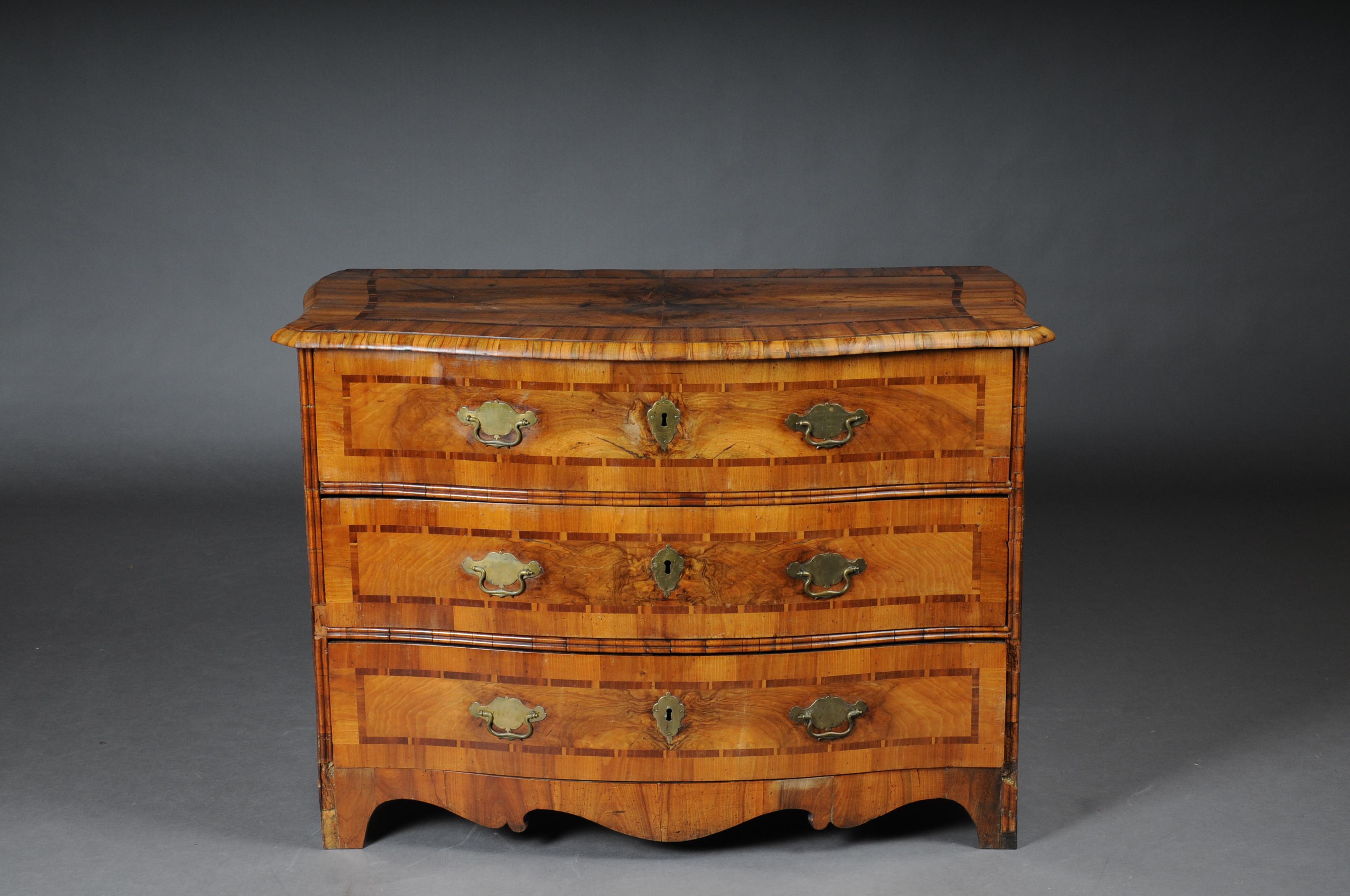 Baroque chest of drawers in walnut, German, circa 1740.

Various fine wood veneers on solid fir wood. Profile framed fit curly frame on feet. In the cambered front three drawers, in the front and on the side walls wide framed and inlaid