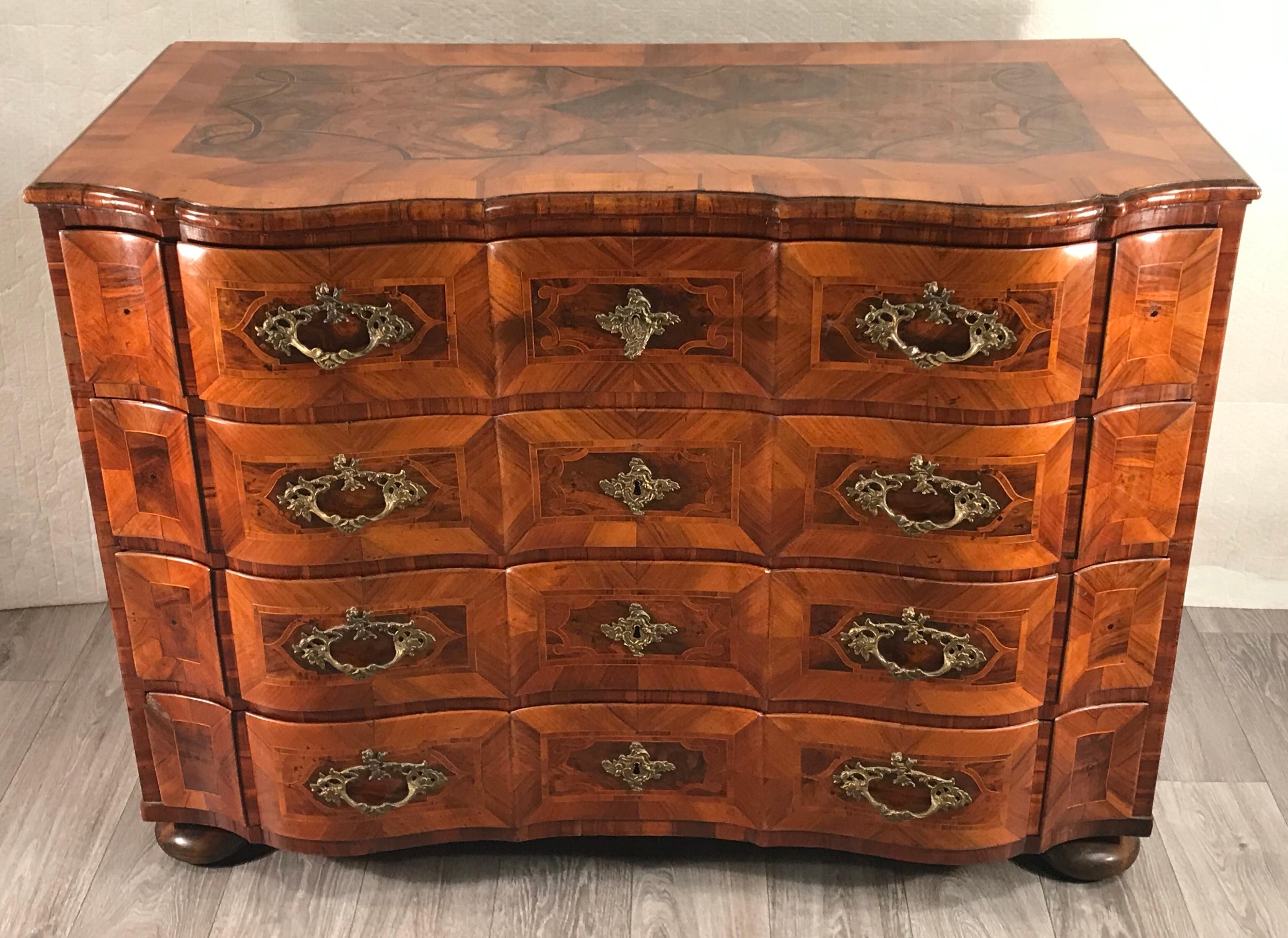 Baroque chest of drawers, Southern Germany 1750, walnut veneer with inlays in plum wood.
This unique beautiful chest of drawers has four drawers and different beautiful walnut veneer grains. The top has inlays of plum wood. Additionally, the