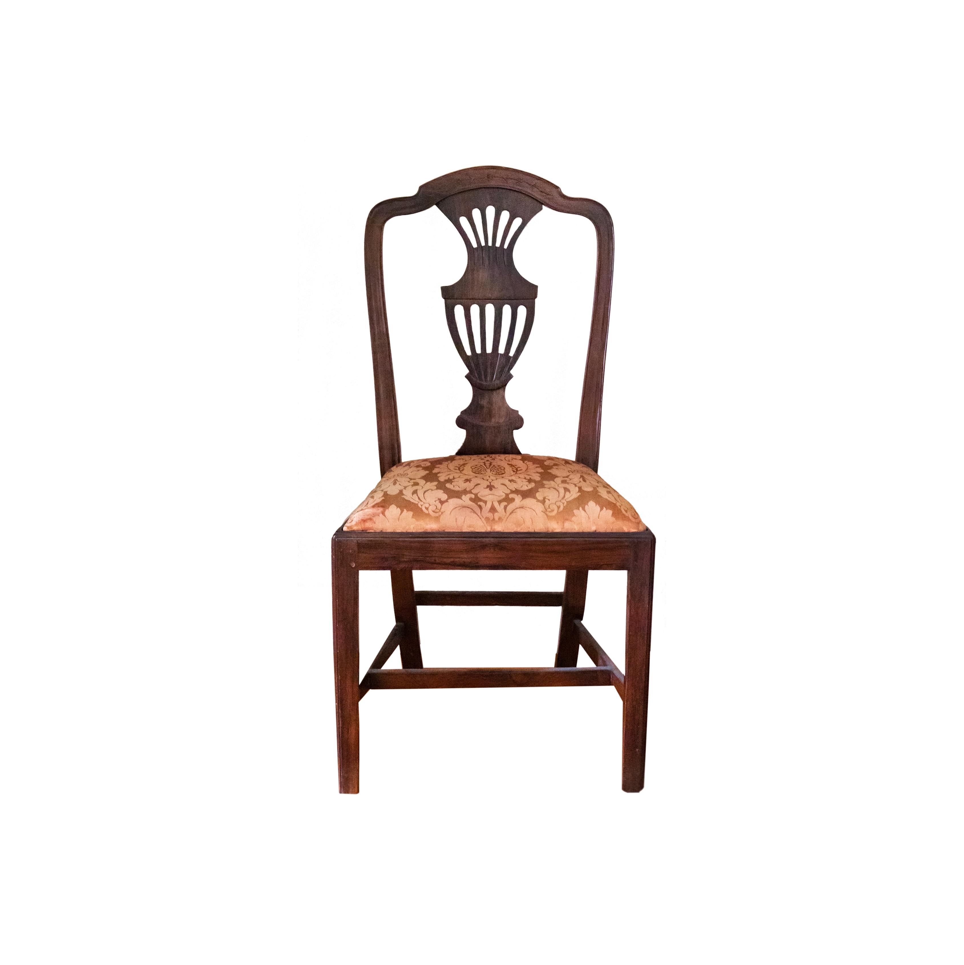 This 19th-century chair showcases the elegant Chippendale style, featuring a gracefully curved amphora back design and adorned with exquisite damascus upholstery. It has been meticulously cared for and has undergone a recent inspection by a skilled